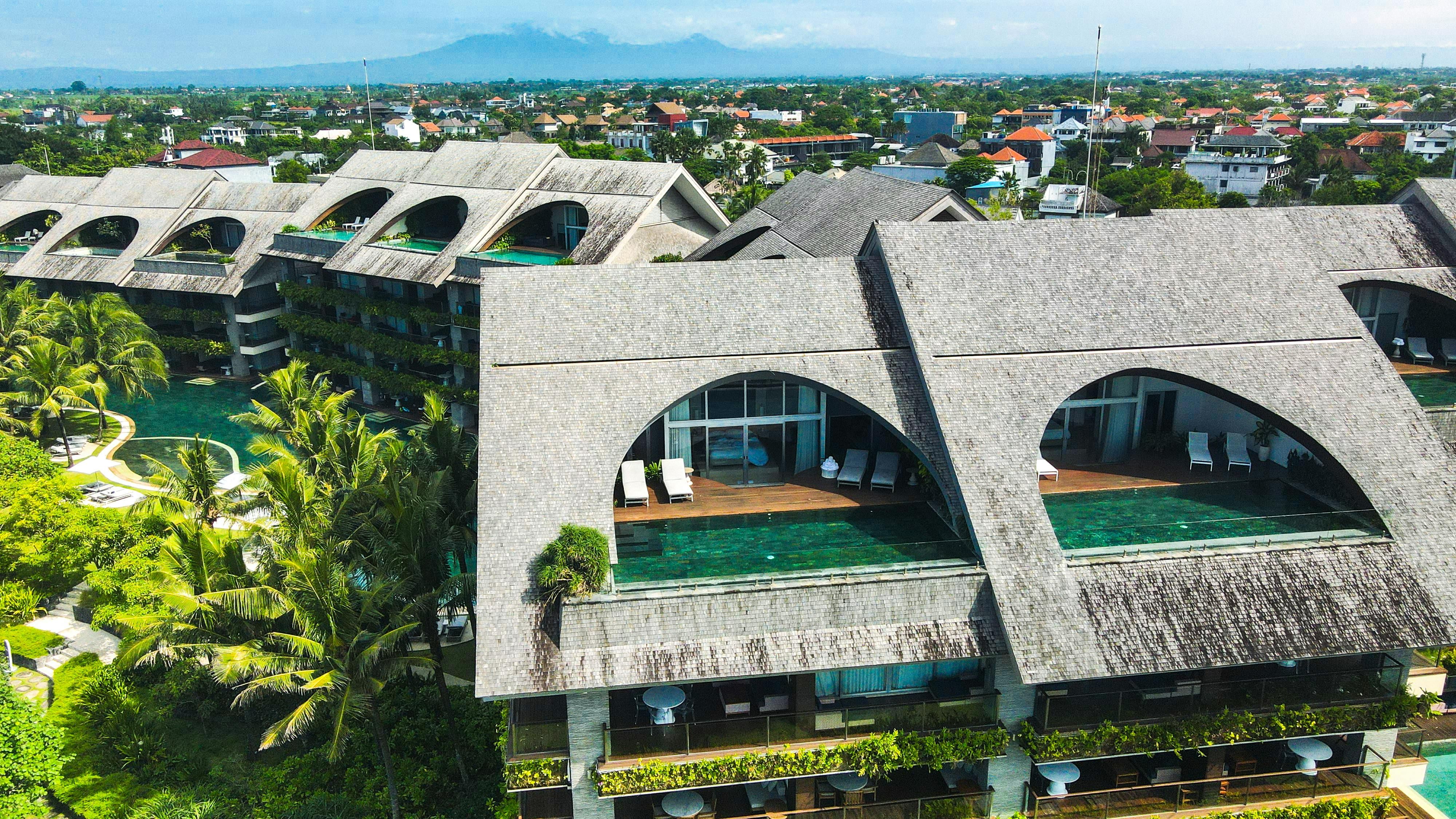 Bali — Aerial view of a contemporary resort in Bali, showcasing unique design with lush green landscapes and a pool.