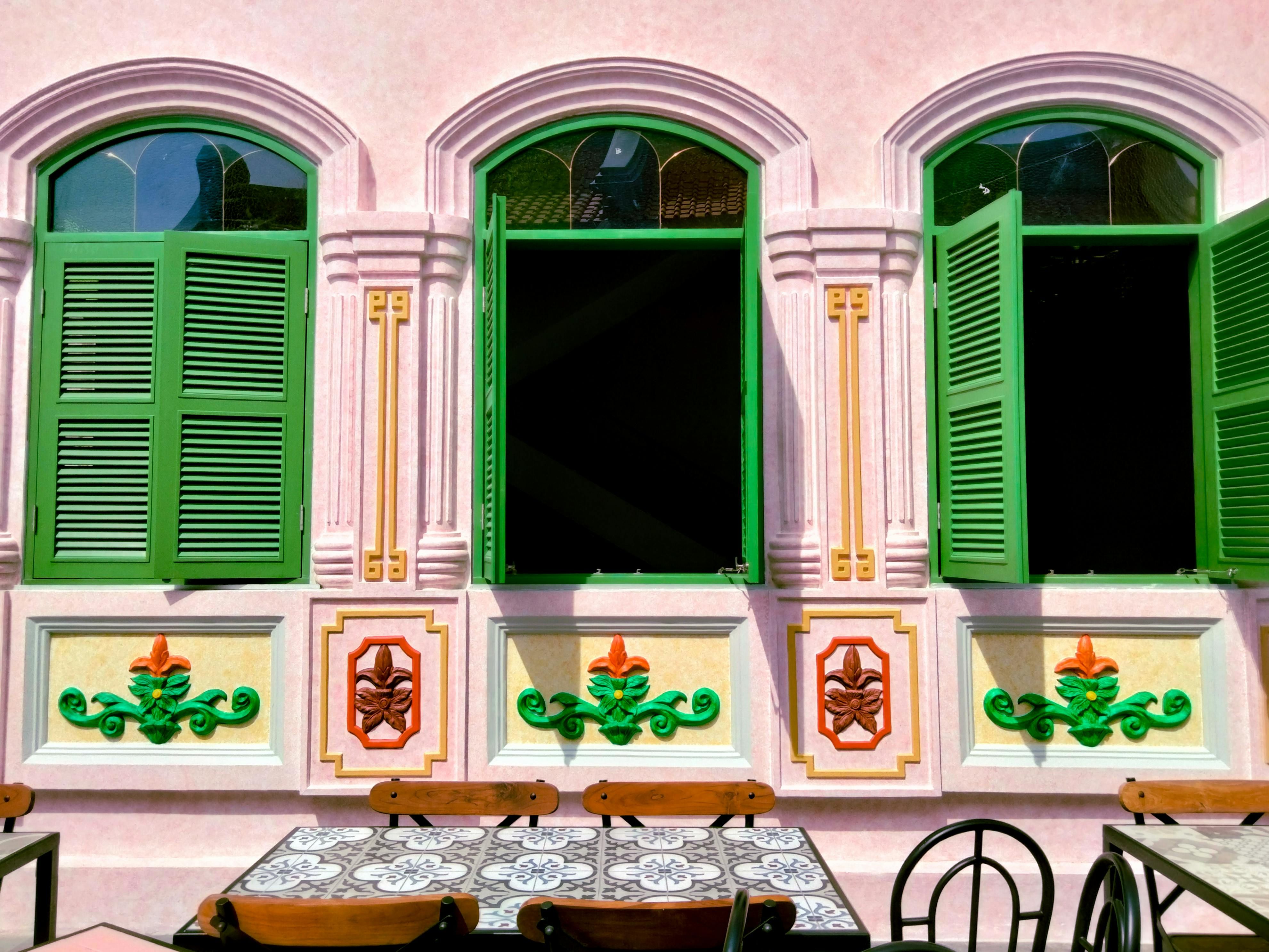 Bali — Beautiful pink facade with green shutters and ornate design, showcasing vibrant traditional architecture.