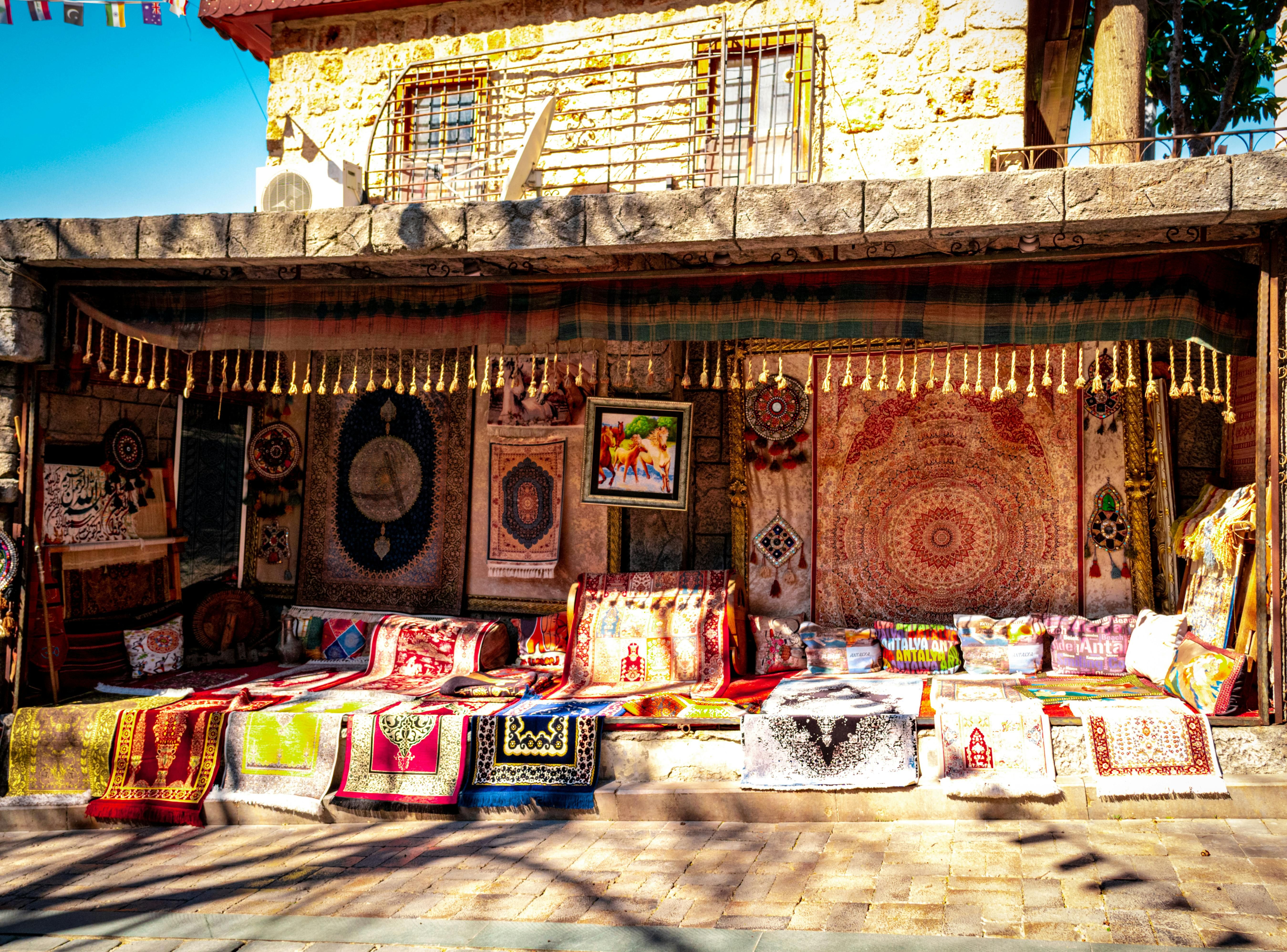 Bali — A vibrant display of traditional carpets and textiles outside a rustic store.
