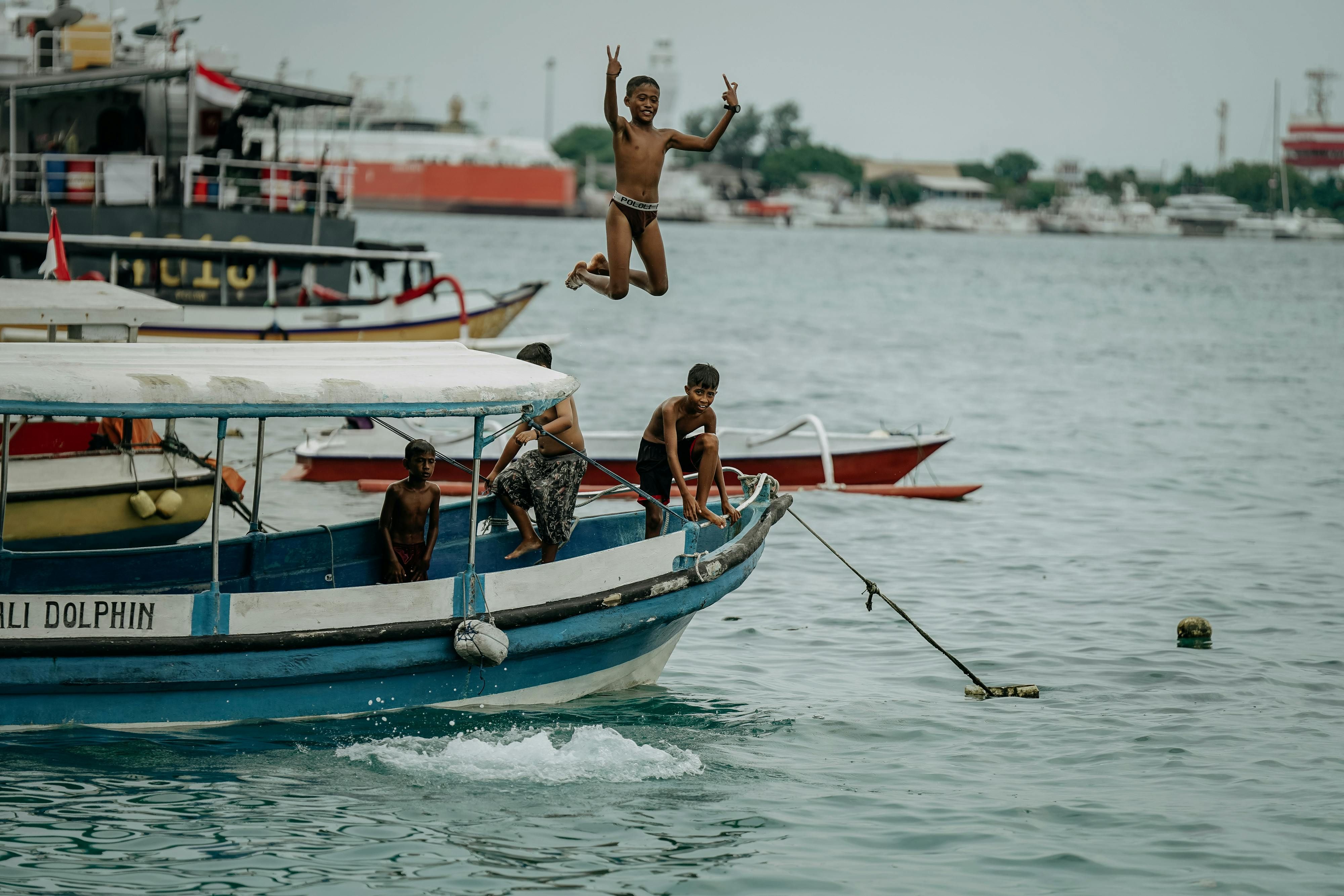 Bali — Joyful moments as children jump from a boat in Kuta Selatan, Bali, Indonesia.