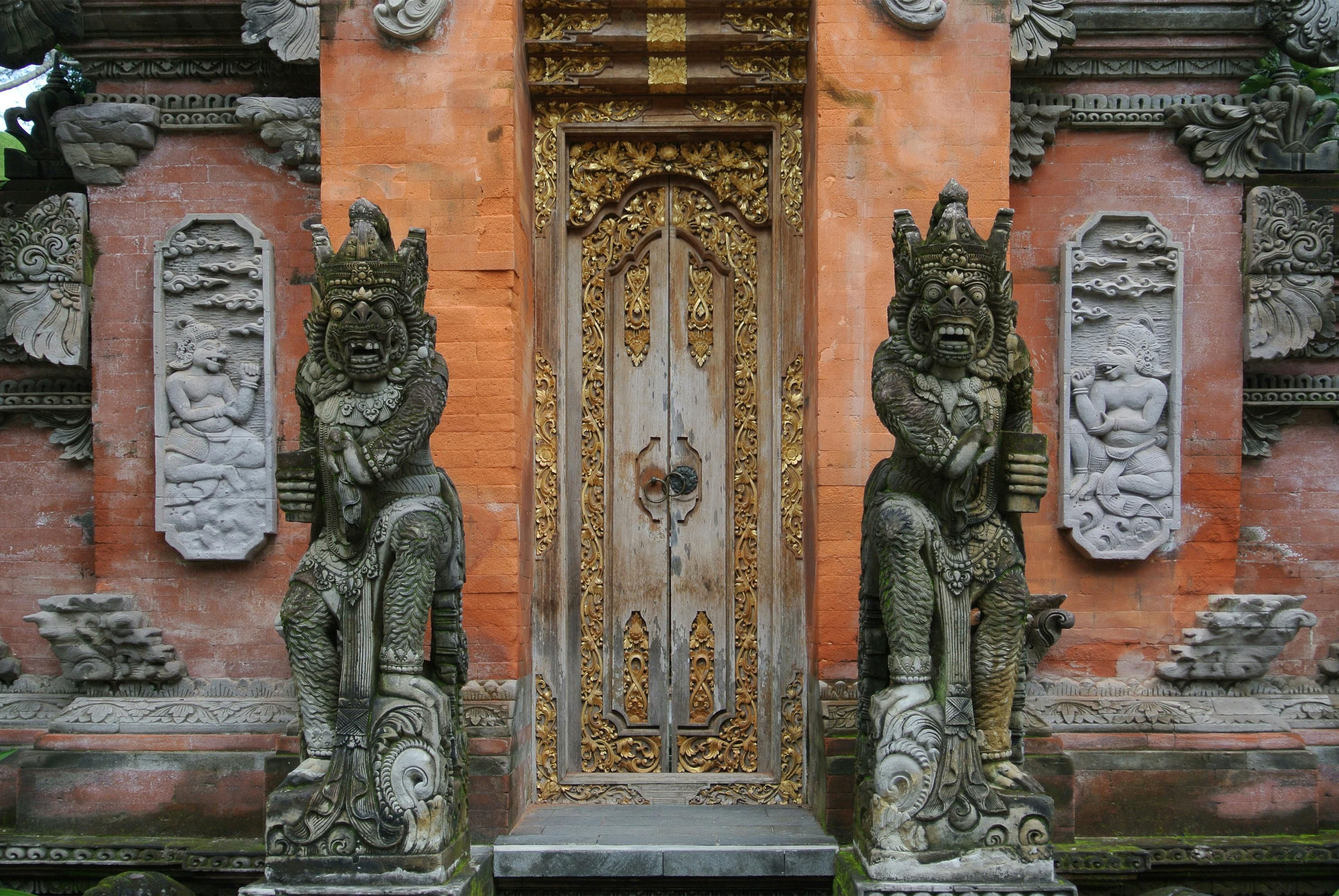 Bali — Capturing the ornate entrance of a Balinese temple in Ubud with detailed stone carvings and golden accents.