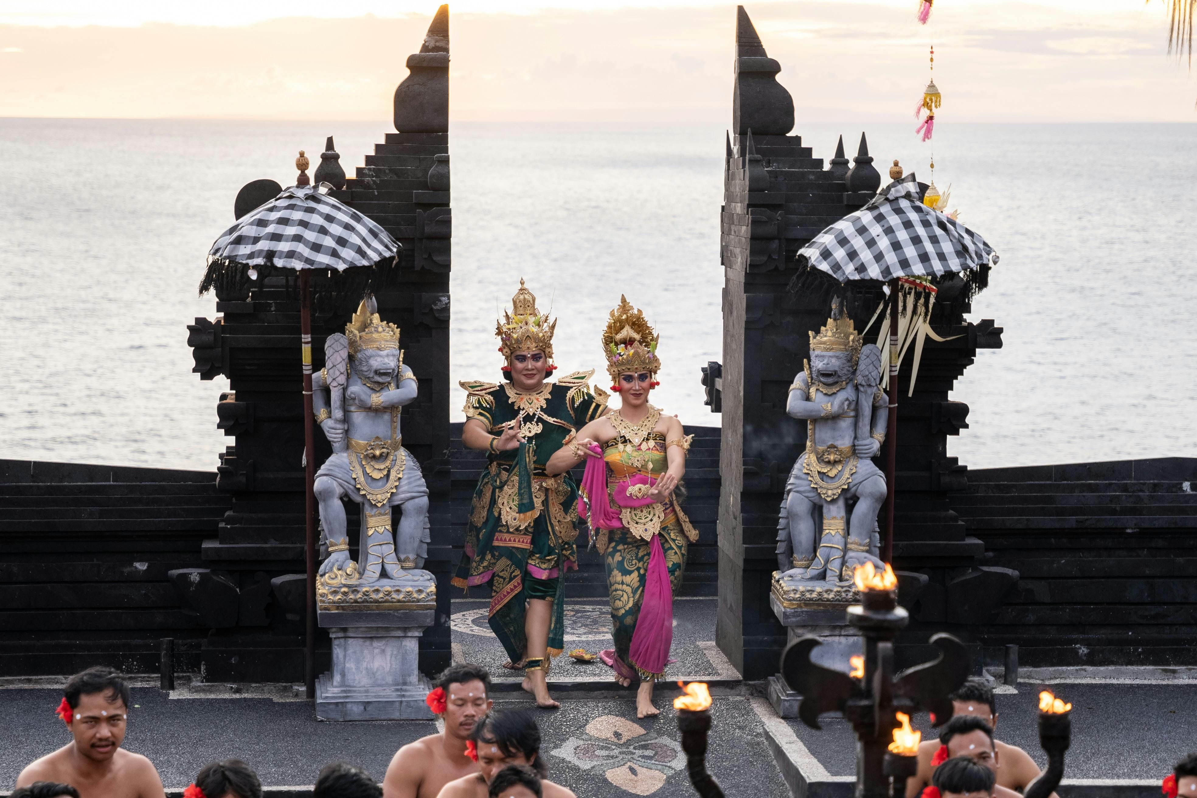 Bali — Balinese dancers perform at the iconic Uluwatu Temple during sunset, showcasing vibrant traditional attire.