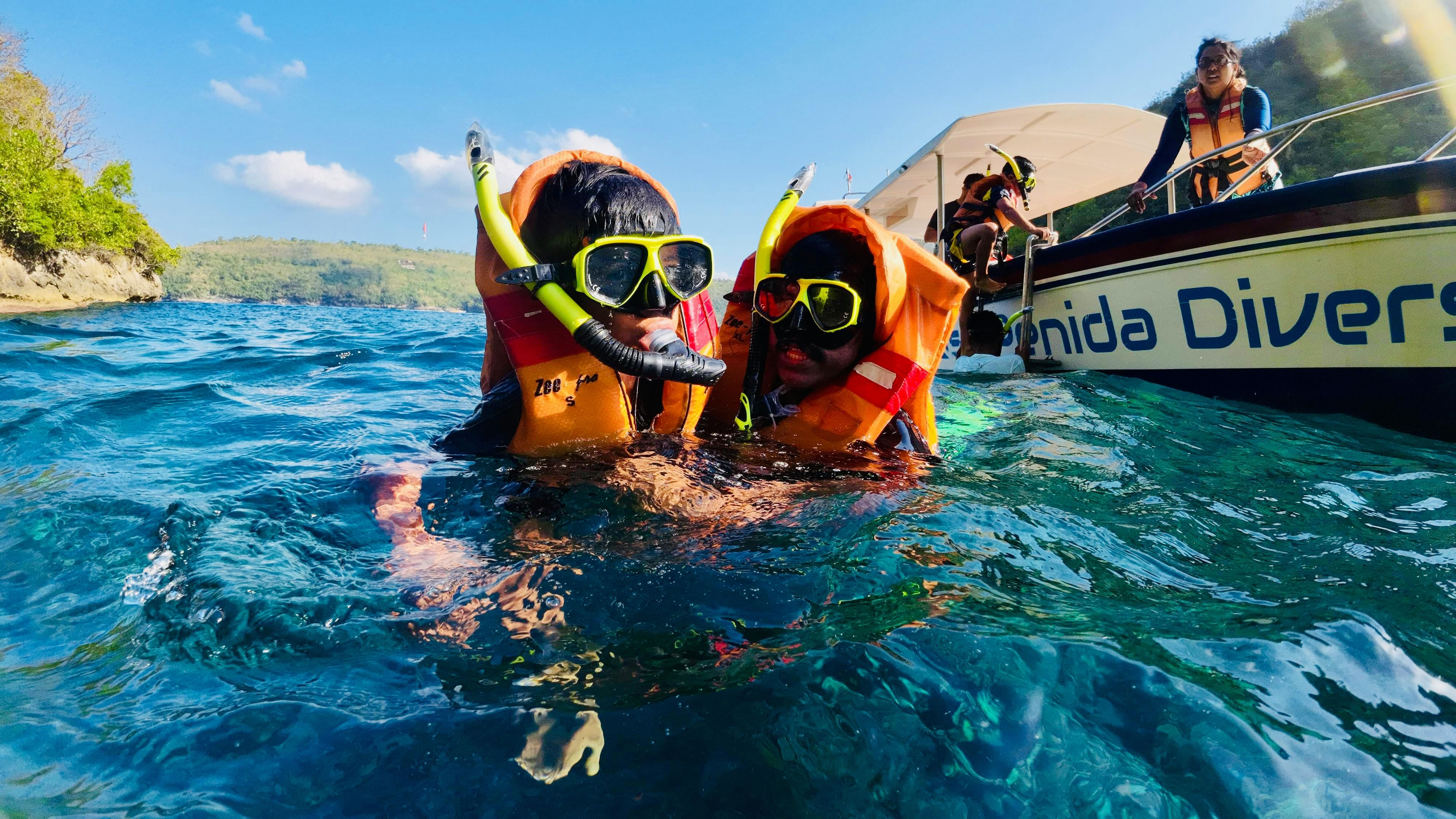 Bali — Two children snorkeling near Nusa Penida in Bali with life jackets and snorkel gear.