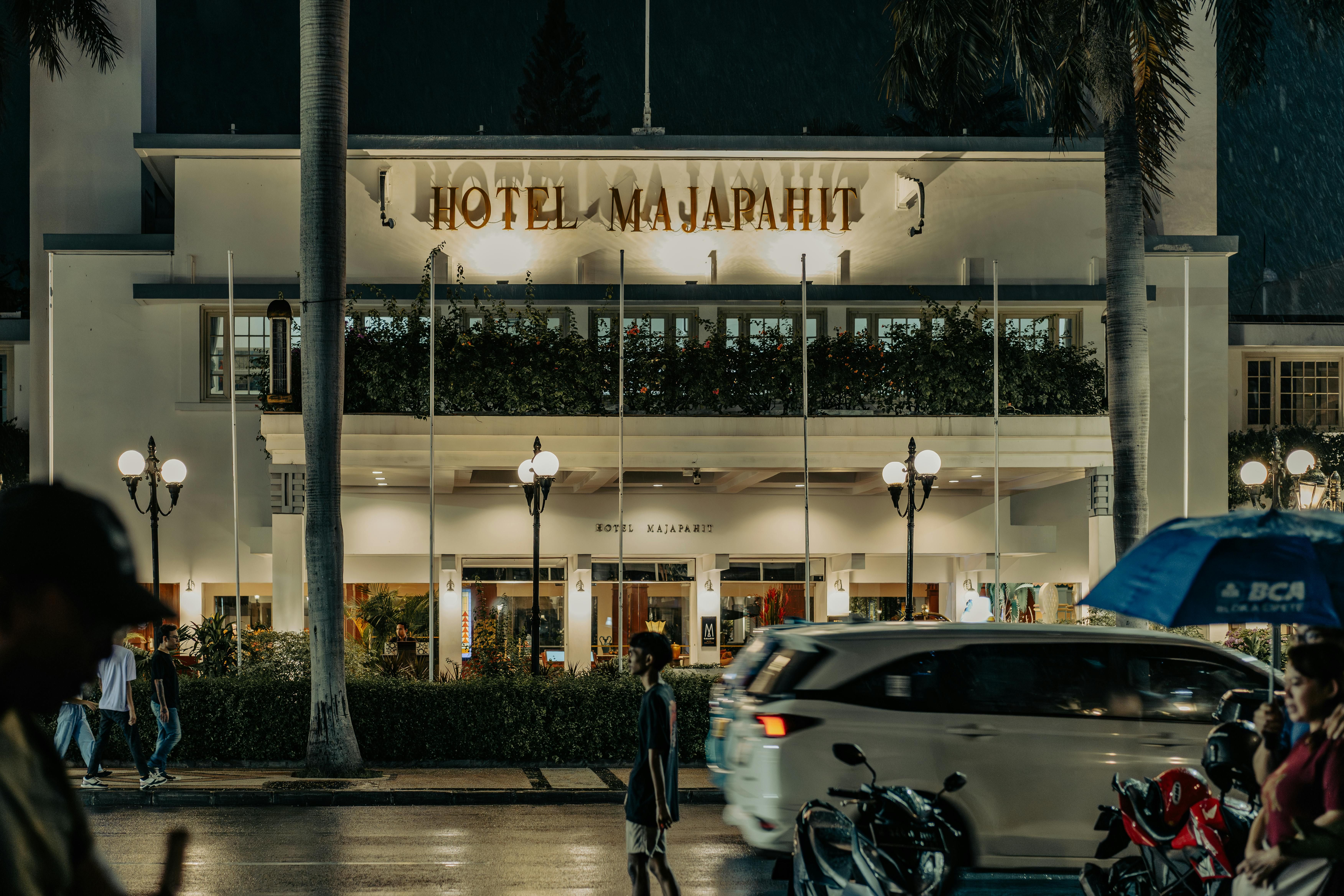 Bali — Night view of the historic Hotel Majapahit in Surabaya, featuring street activity and vibrant lights.