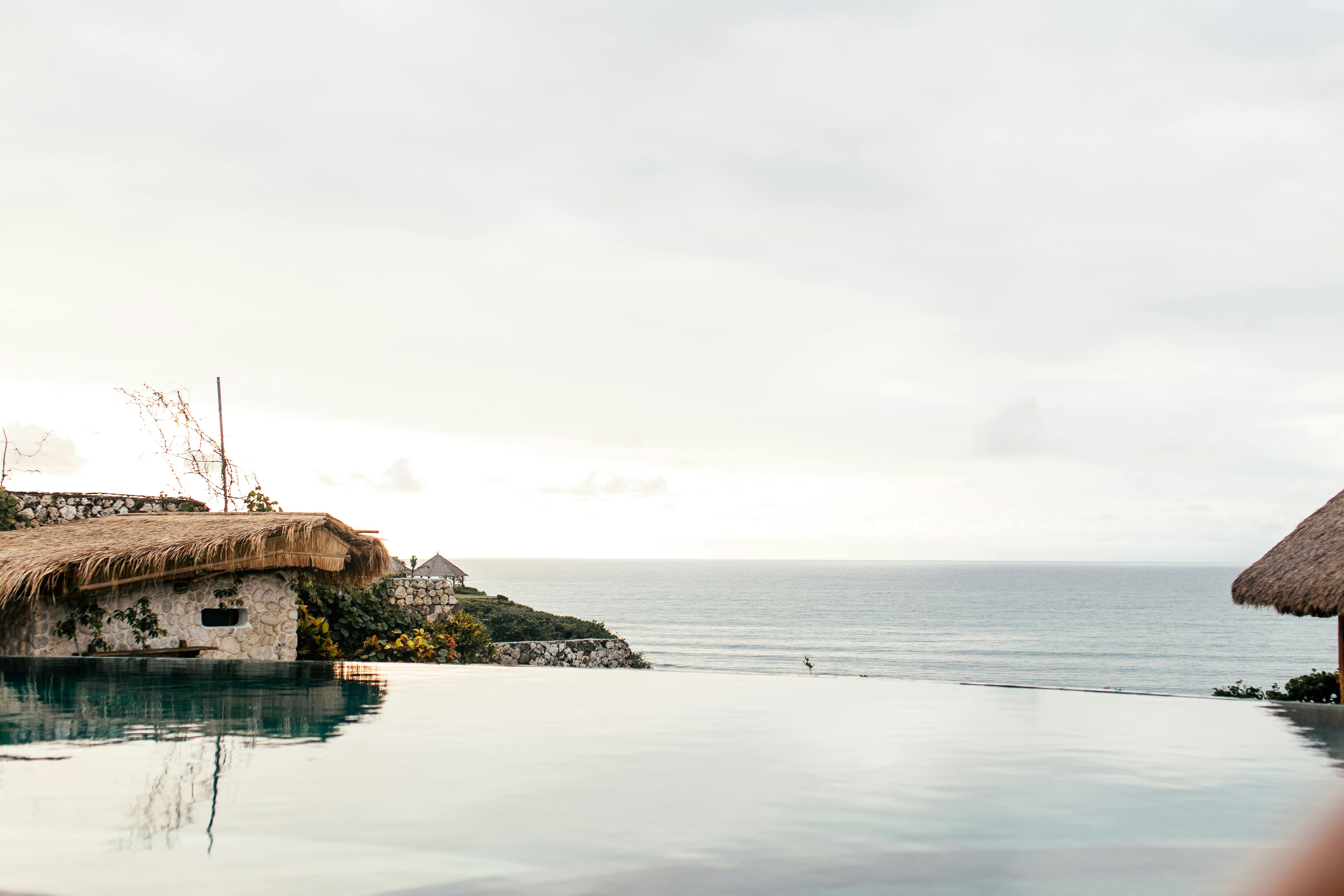 Bali — Serene infinity pool with panoramic sea view at a tropical resort.