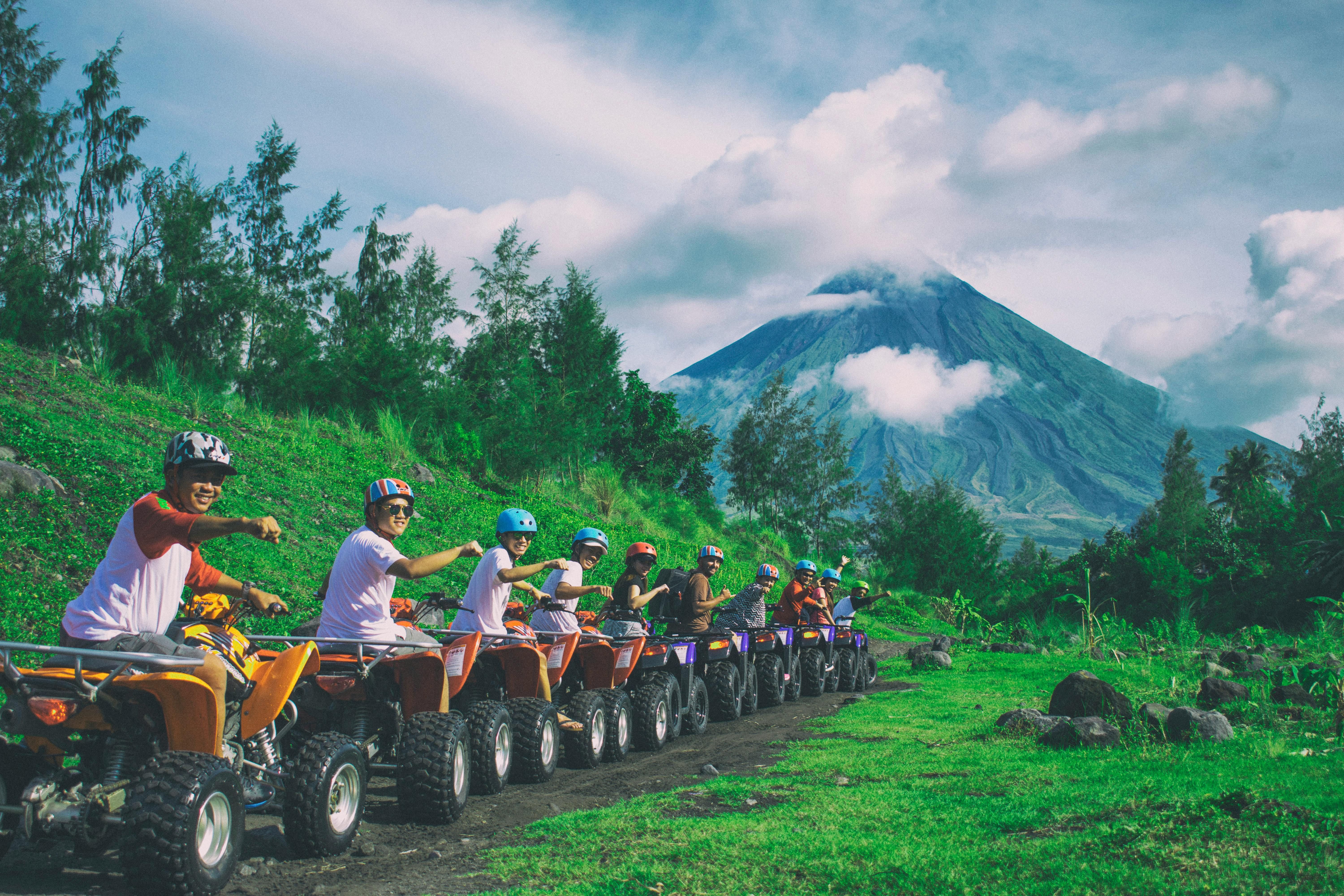 Bali — Group of friends enjoying an ATV ride with Mayon Volcano in the background.