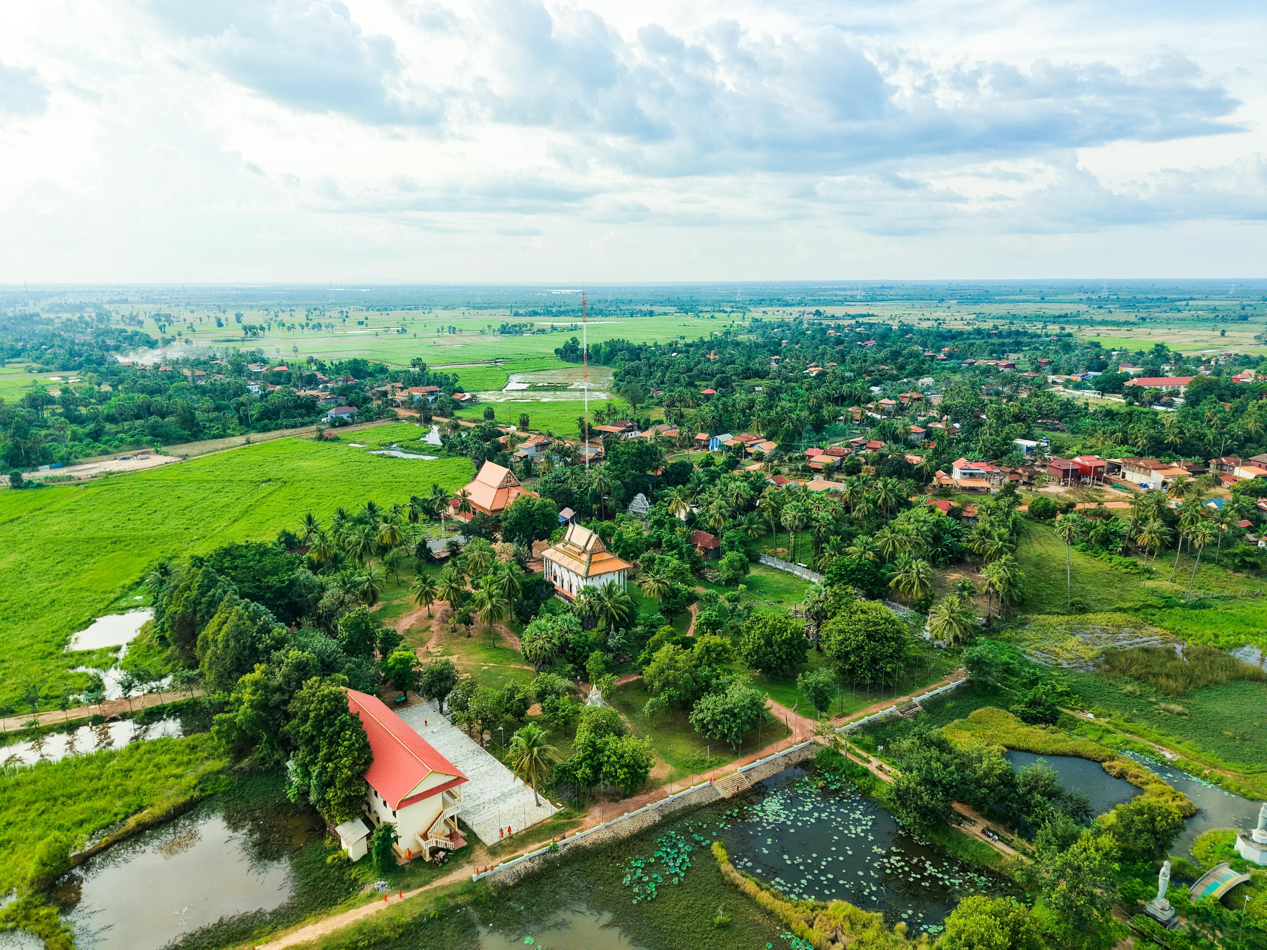 Cambodia — Scenic aerial view of lush Cambodian countryside with traditional temples and vast green fields.