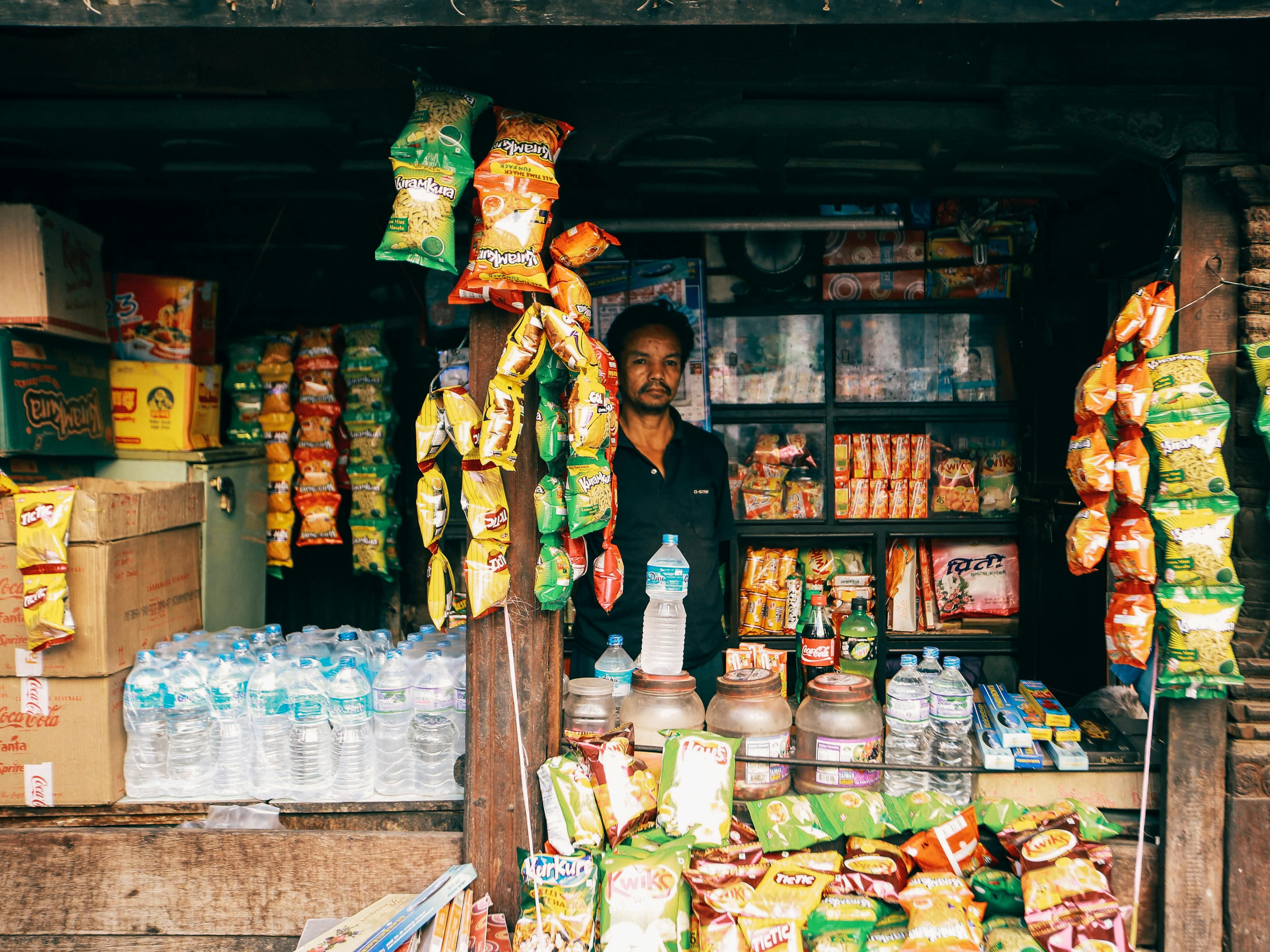 Fiji — Image of a vendor in a vibrant local convenience store selling snacks and bottled water.