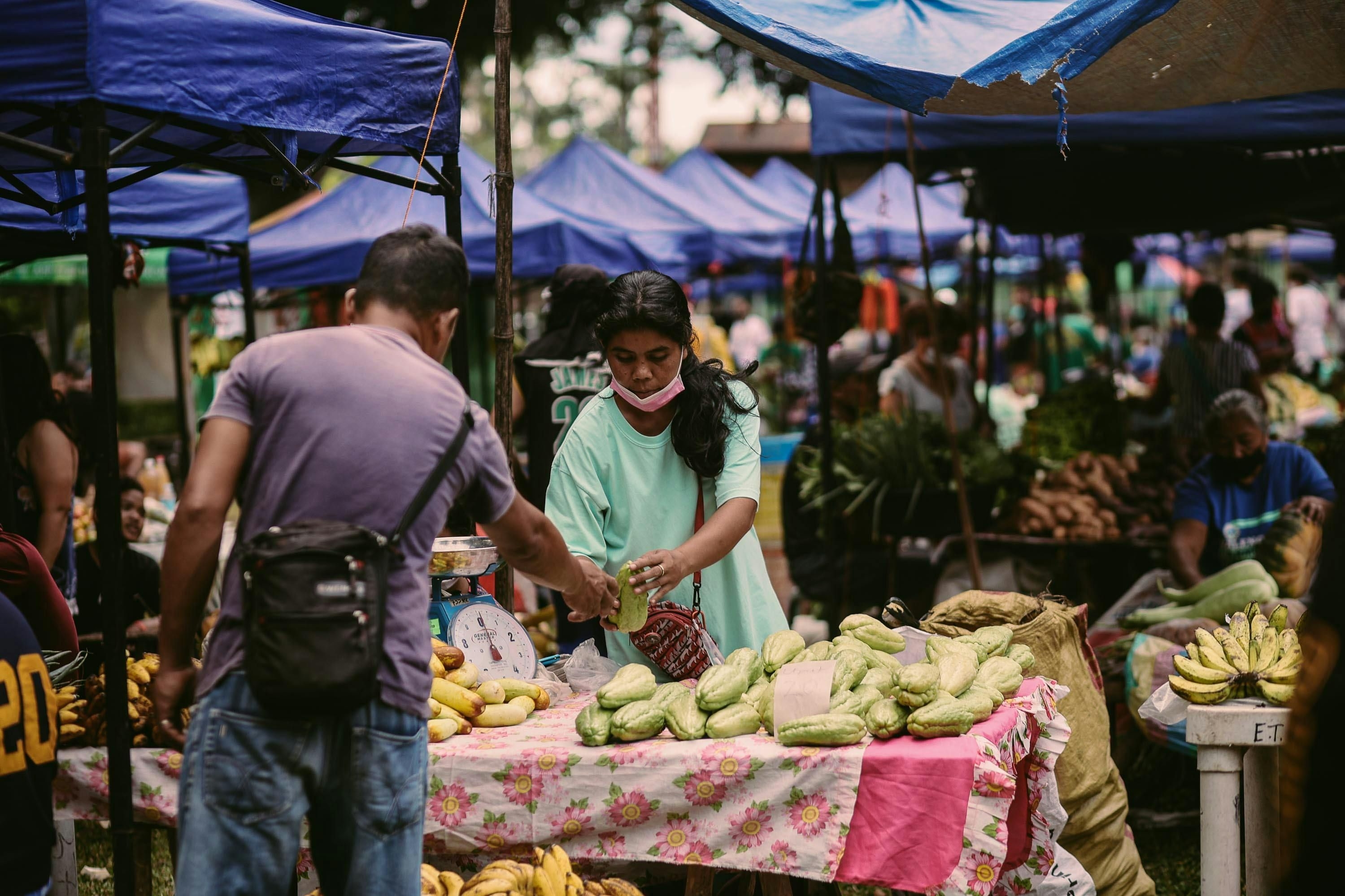 Fiji — A lively public market with vendors selling fresh vegetables and fruits.
