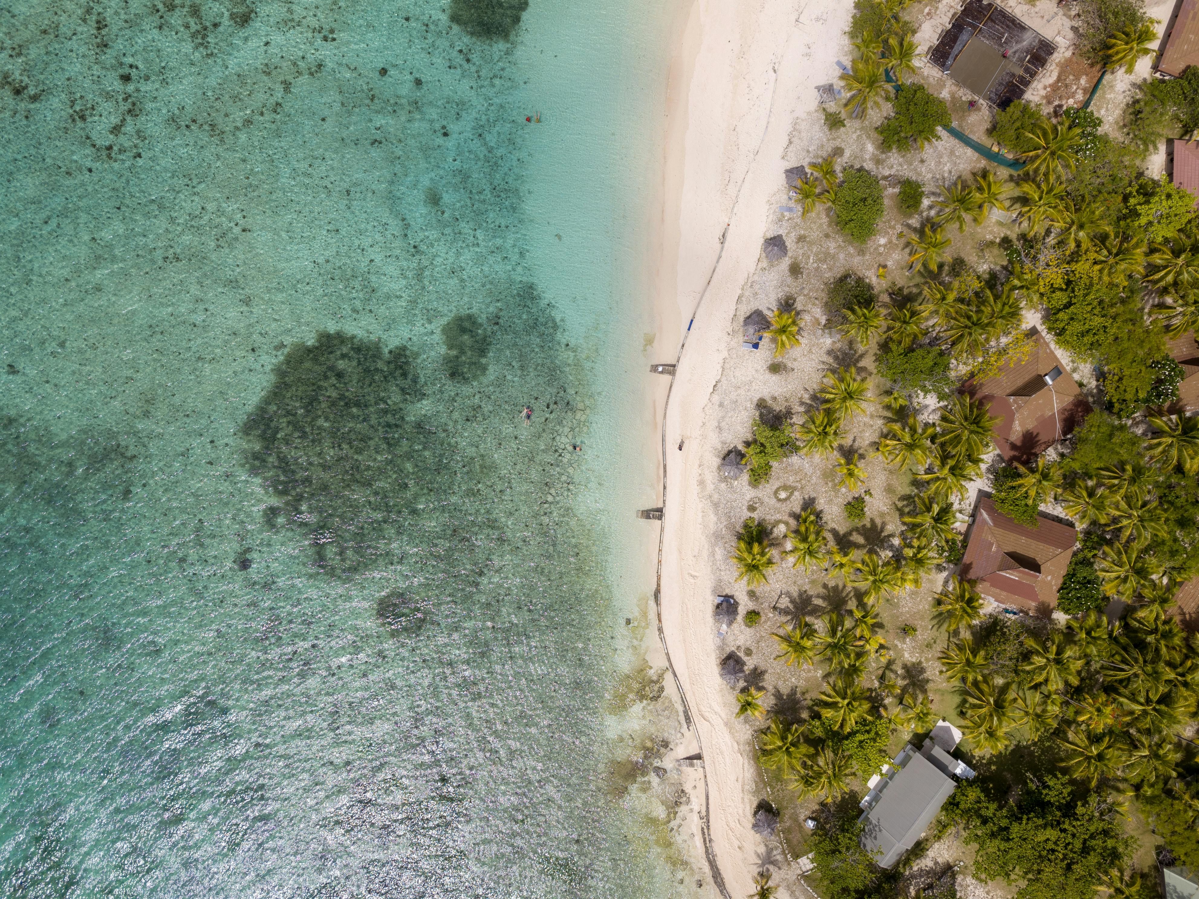 Fiji — Stunning aerial shot of a pristine beach with turquoise water and lush greenery.