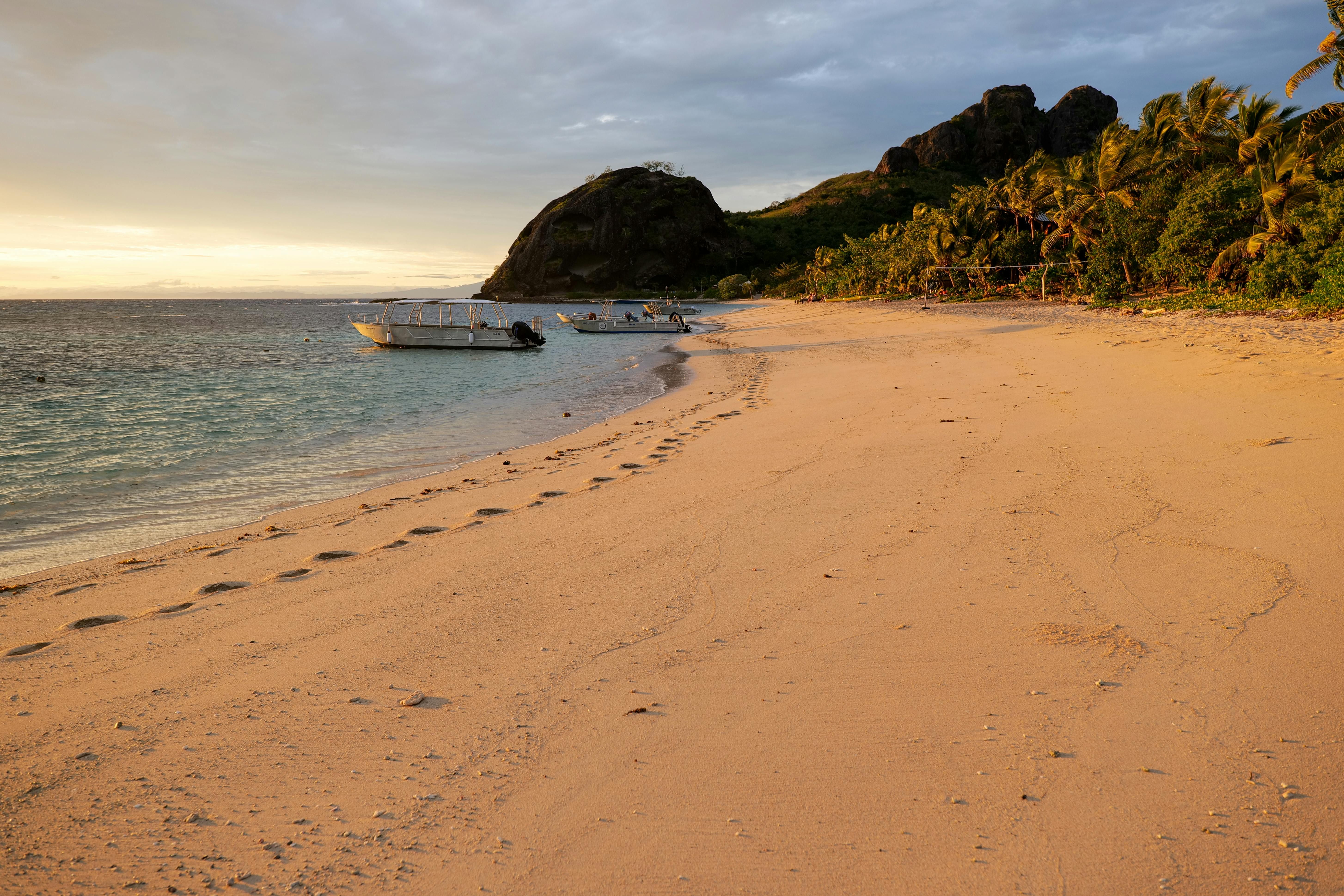 Fiji — Tranquil evening beach scene with boats and palm trees on Yasawa Islands, Fiji.