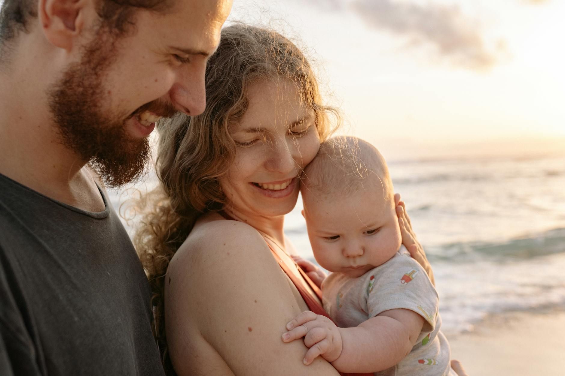 Western young family with baby at the beach during golden hour