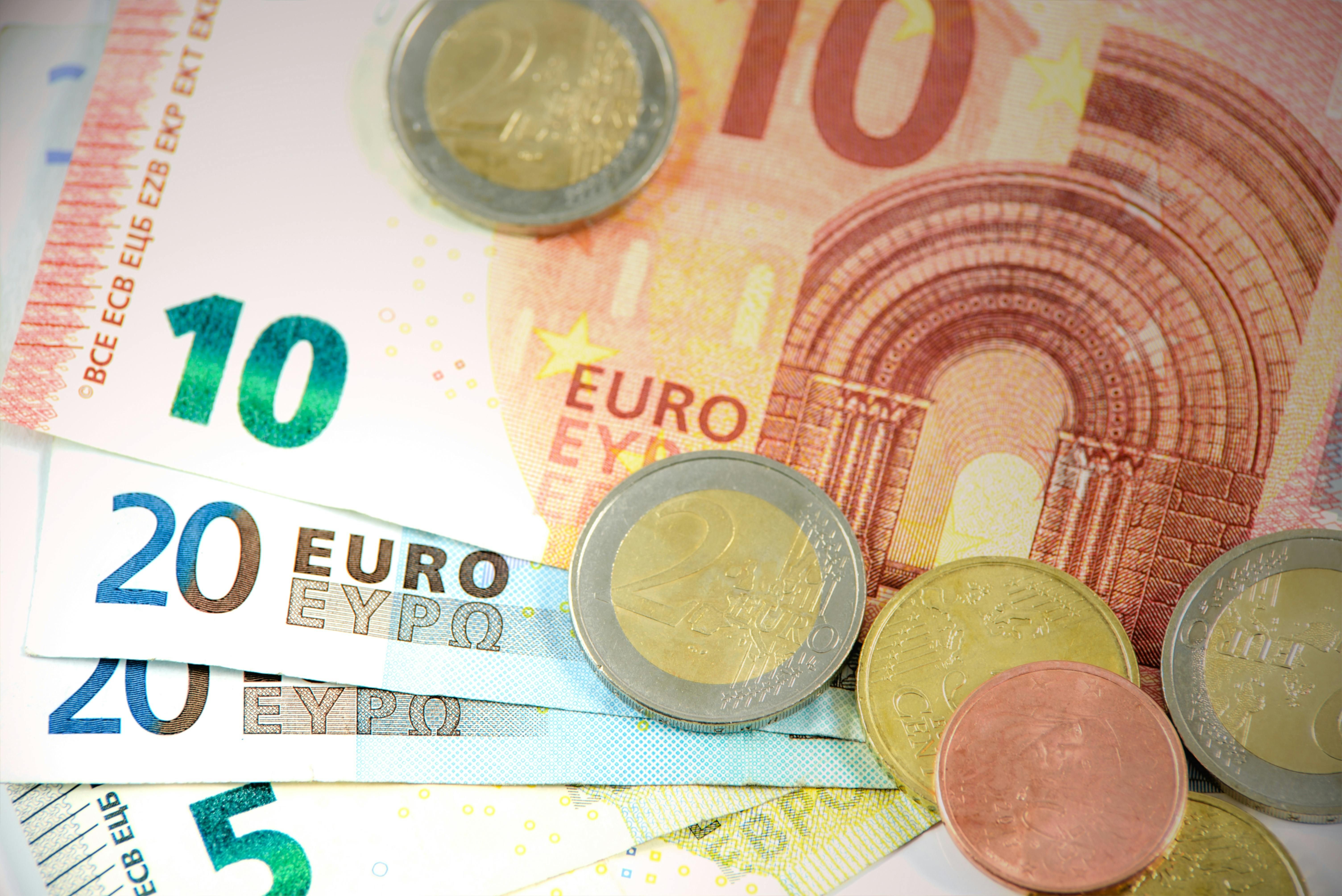 Italy — Detailed shot of Euro banknotes and coins showcasing currency denominations.