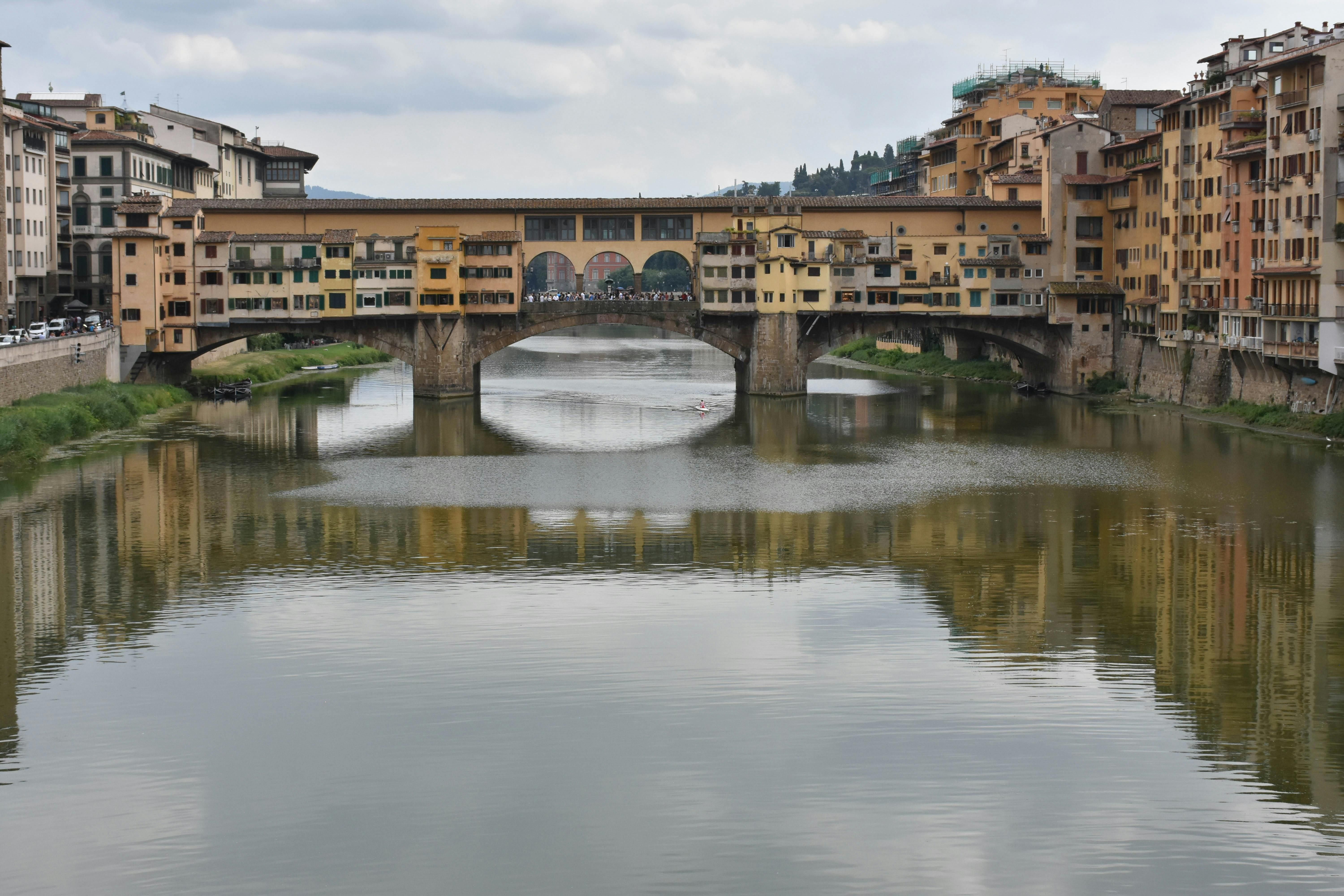 Italy — Discover the timeless beauty of Ponte Vecchio spanning the Arno River in Florence.