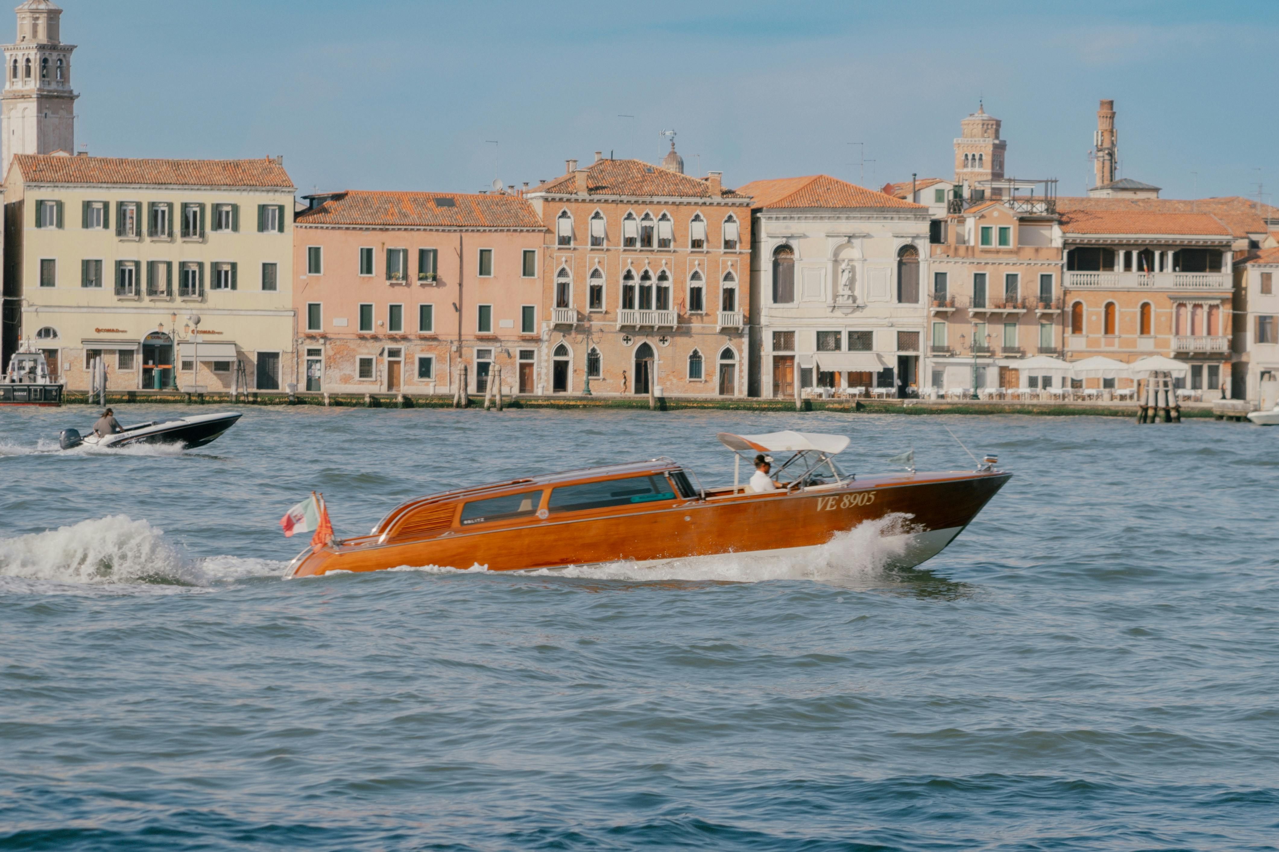 Italy — A traditional Venetian water taxi cruising along the Grand Canal in Venice, Italy, with historic buildings in the background.