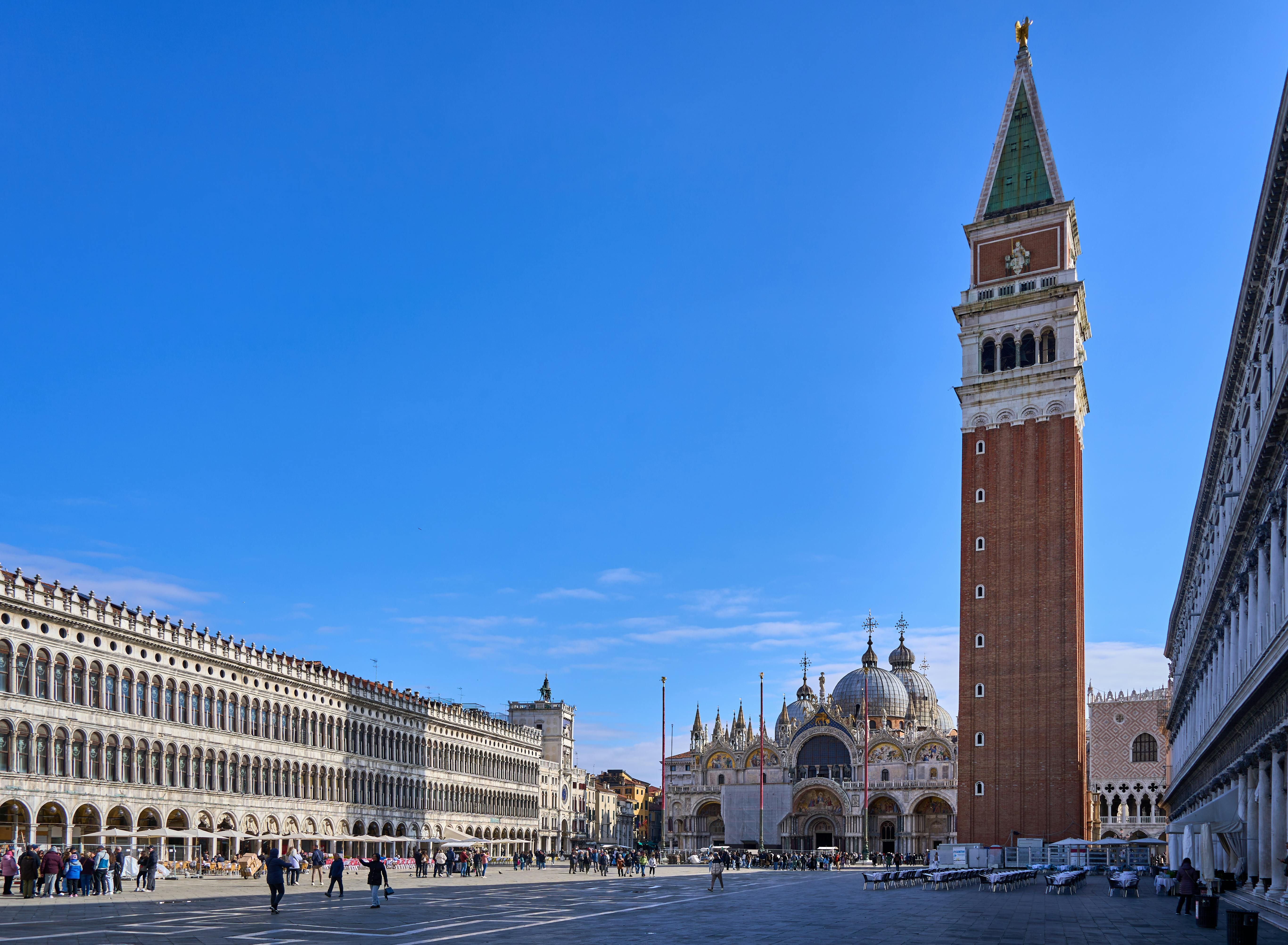 Italy — St. Mark's Campanile and Basilica in Venice's iconic St. Mark's Square under a clear blue sky.