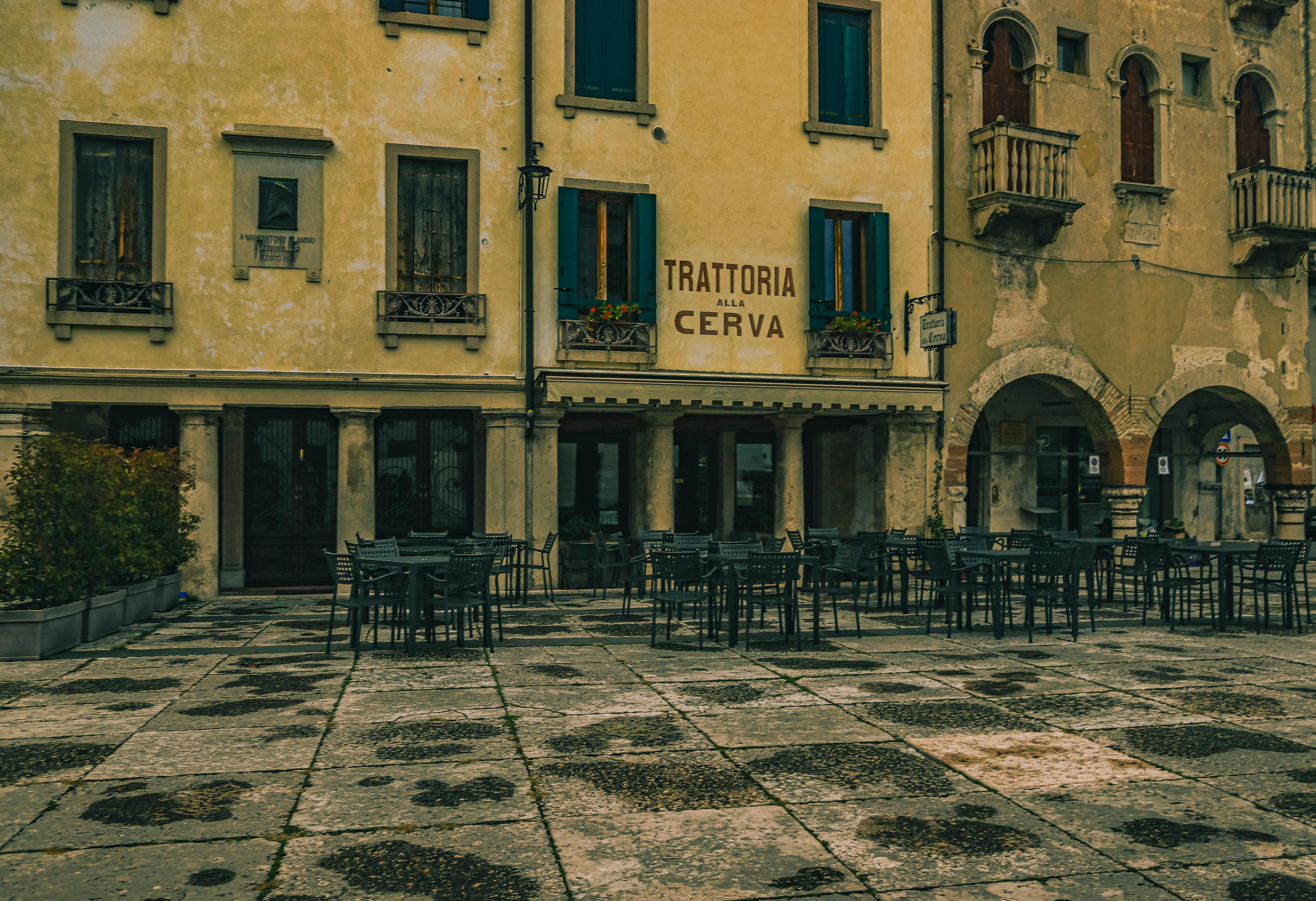 Italy — Explore an empty trattoria in a nostalgic Italian city square with classic architecture.