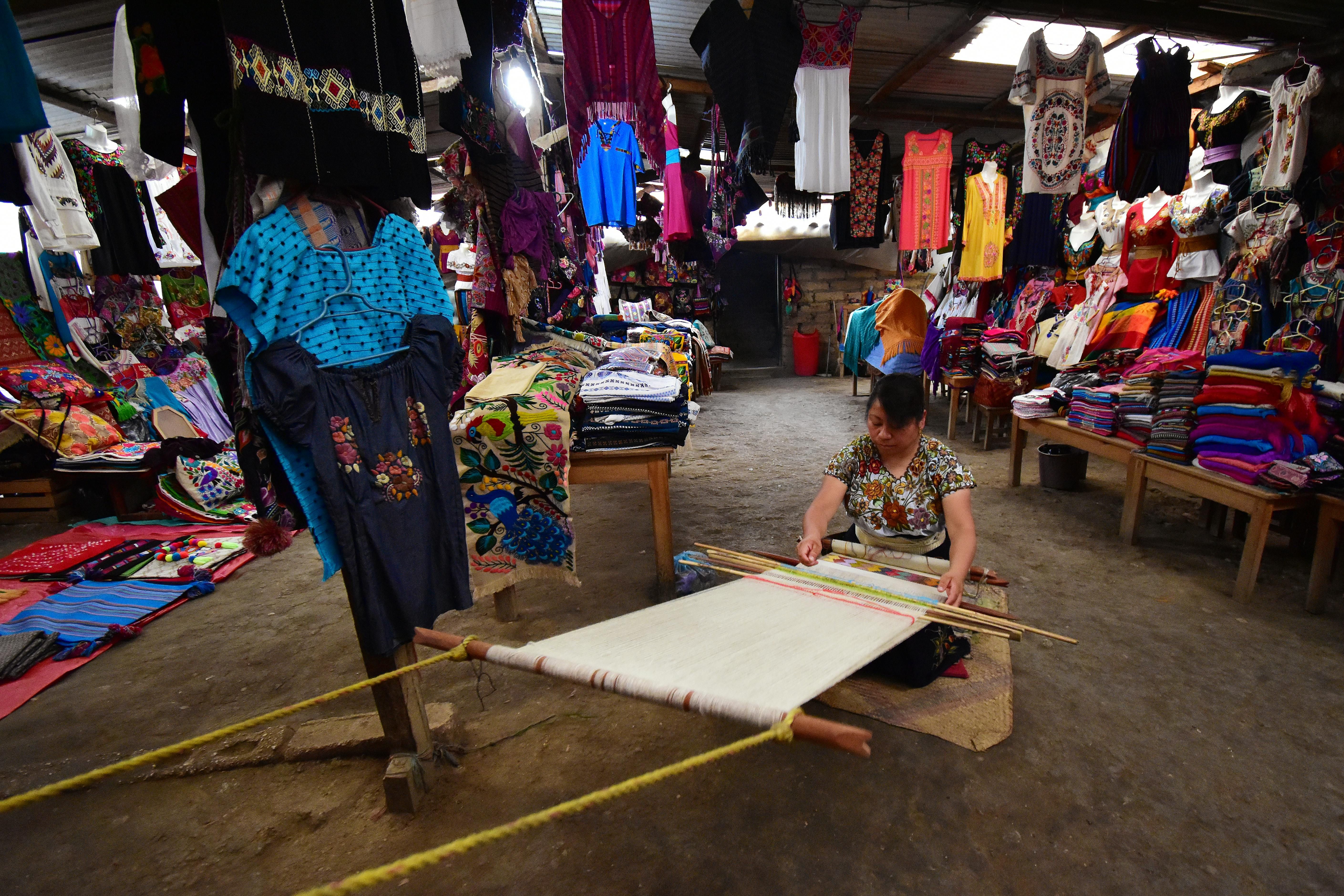 Mexico — Colorful market scene in Zinacantán with woman weaving handmade textiles.