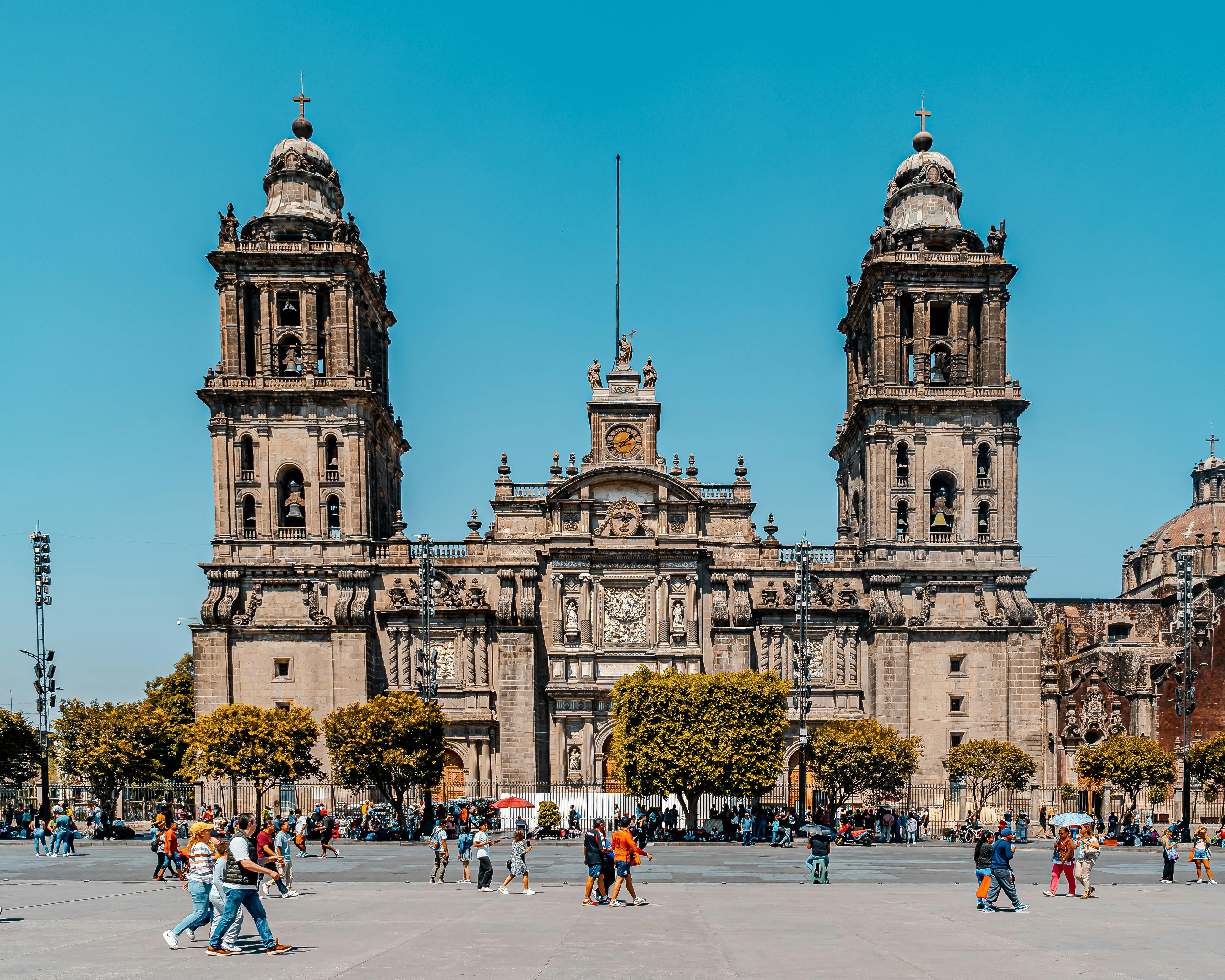Mexico — Stunning view of the Metropolitan Cathedral in Mexico City with clear blue skies and bustling activity.
