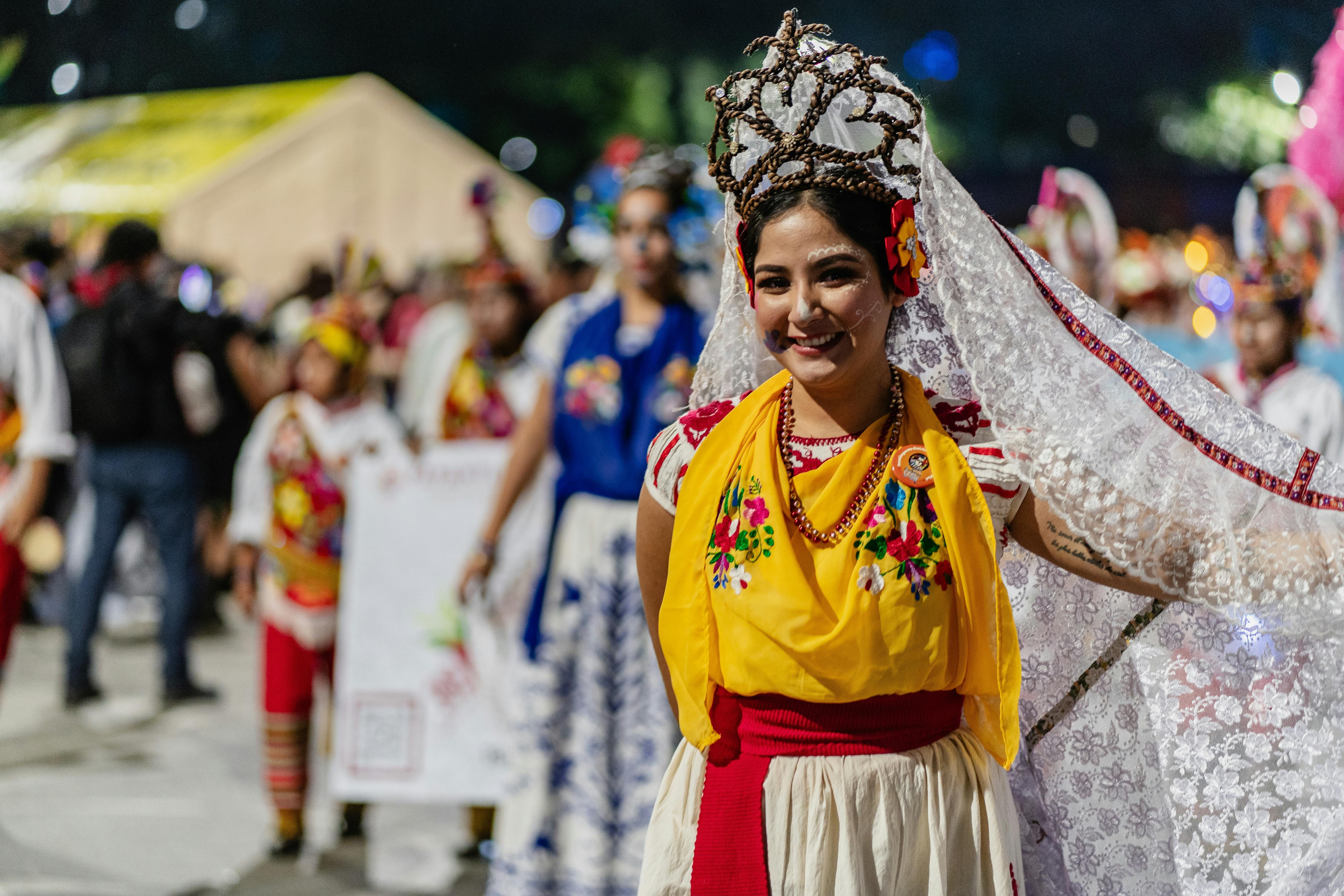 Mexico — A woman in colorful traditional Mexican attire with intricate headdress at a lively festival in Mexico City.