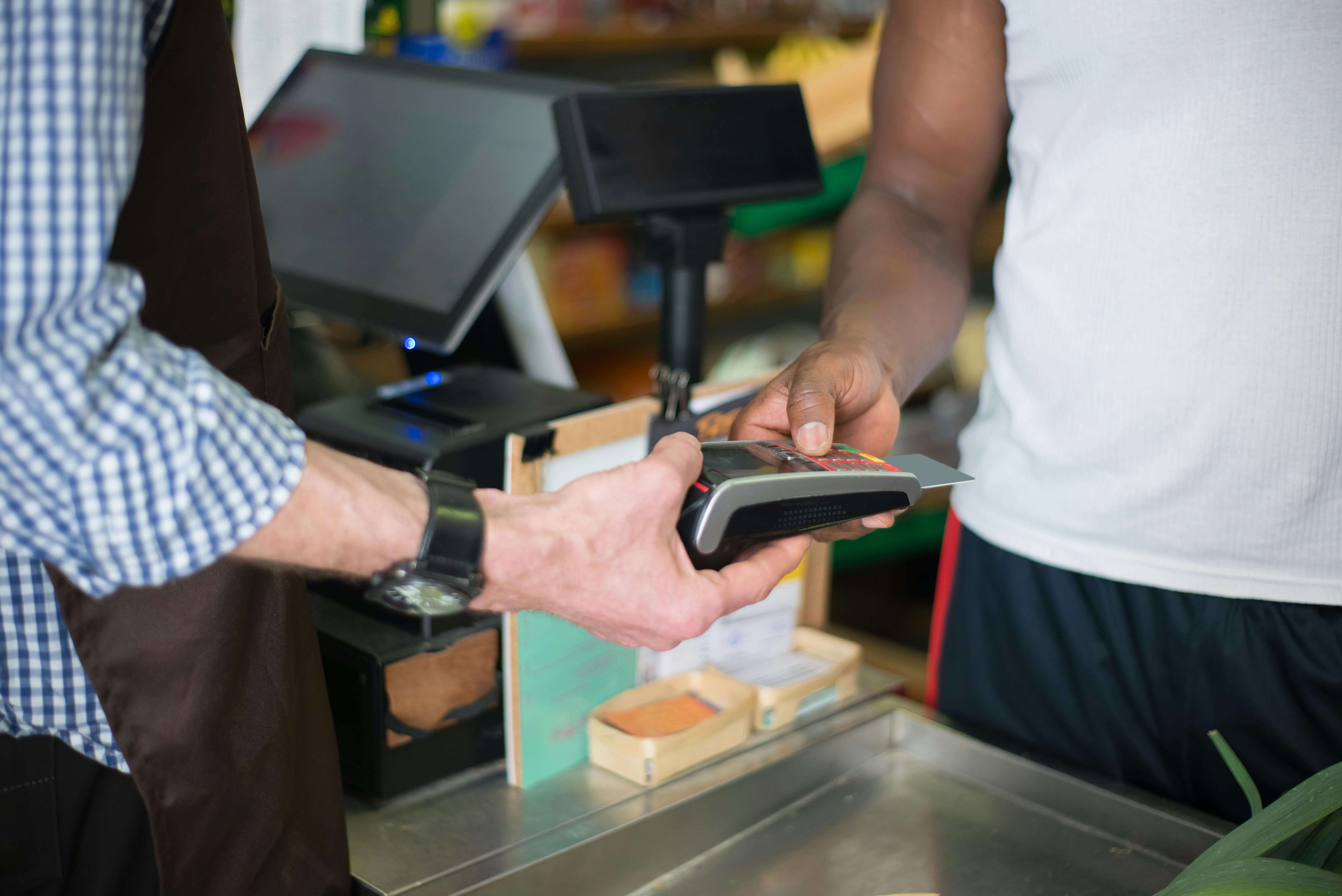 Mexico — A customer making a payment with a credit card at a store checkout counter using a card reader.