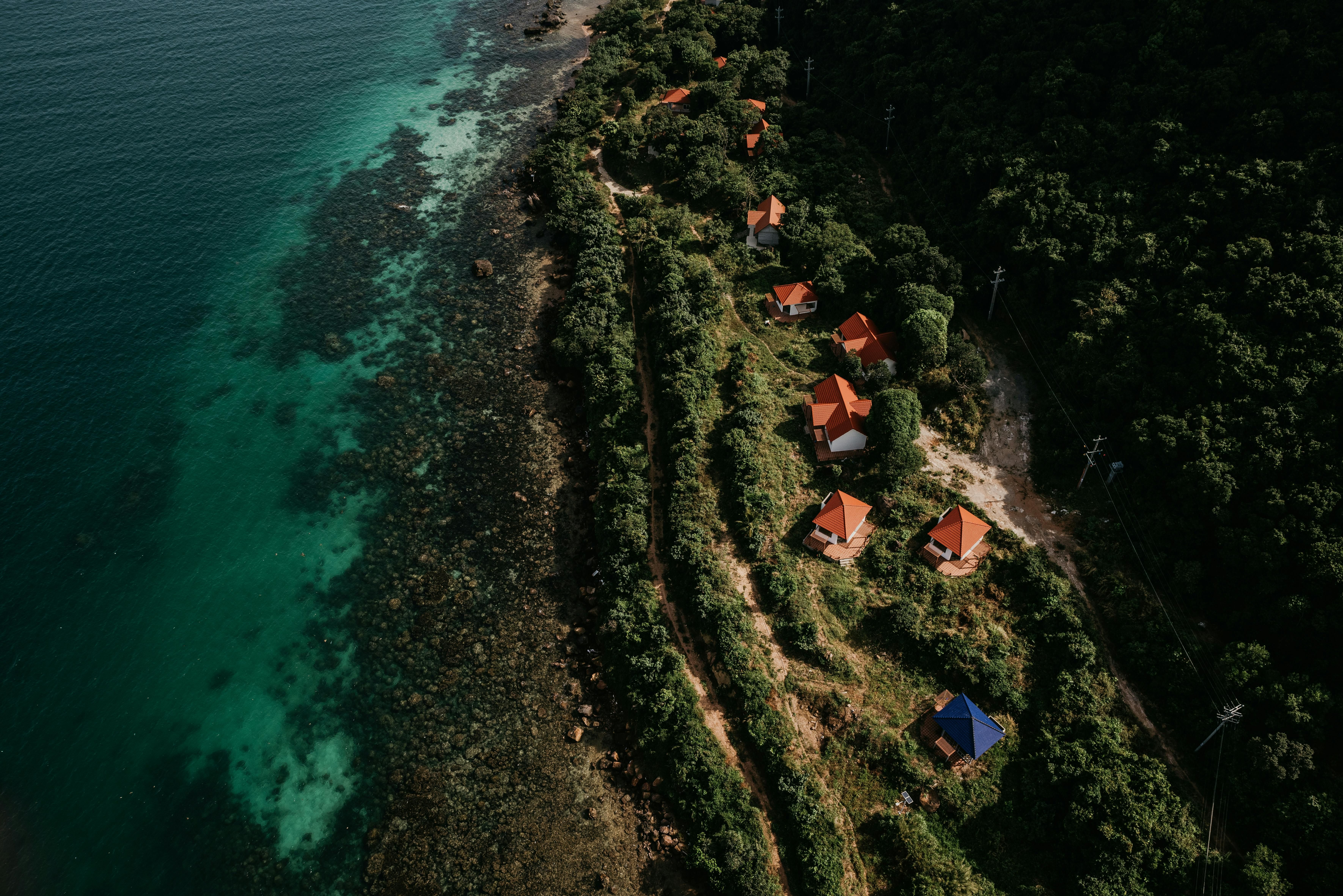 Phu Quoc Landscape — Stunning aerial view of Vietnam's lush coastline with red-roofed houses and clear turquoise waters.
