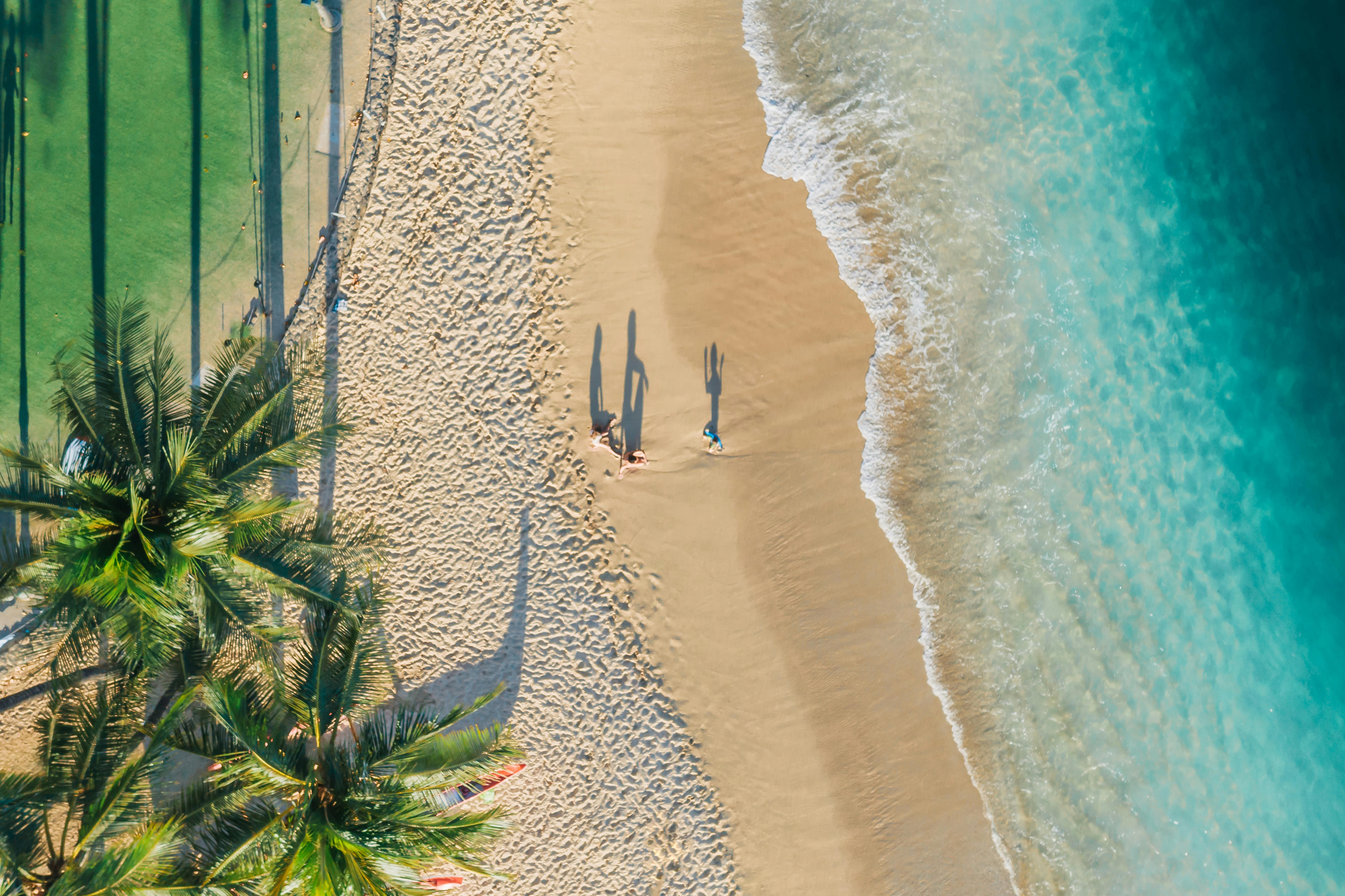 Thailand — Stunning aerial photo of a sandy beach with palm trees and gentle waves.