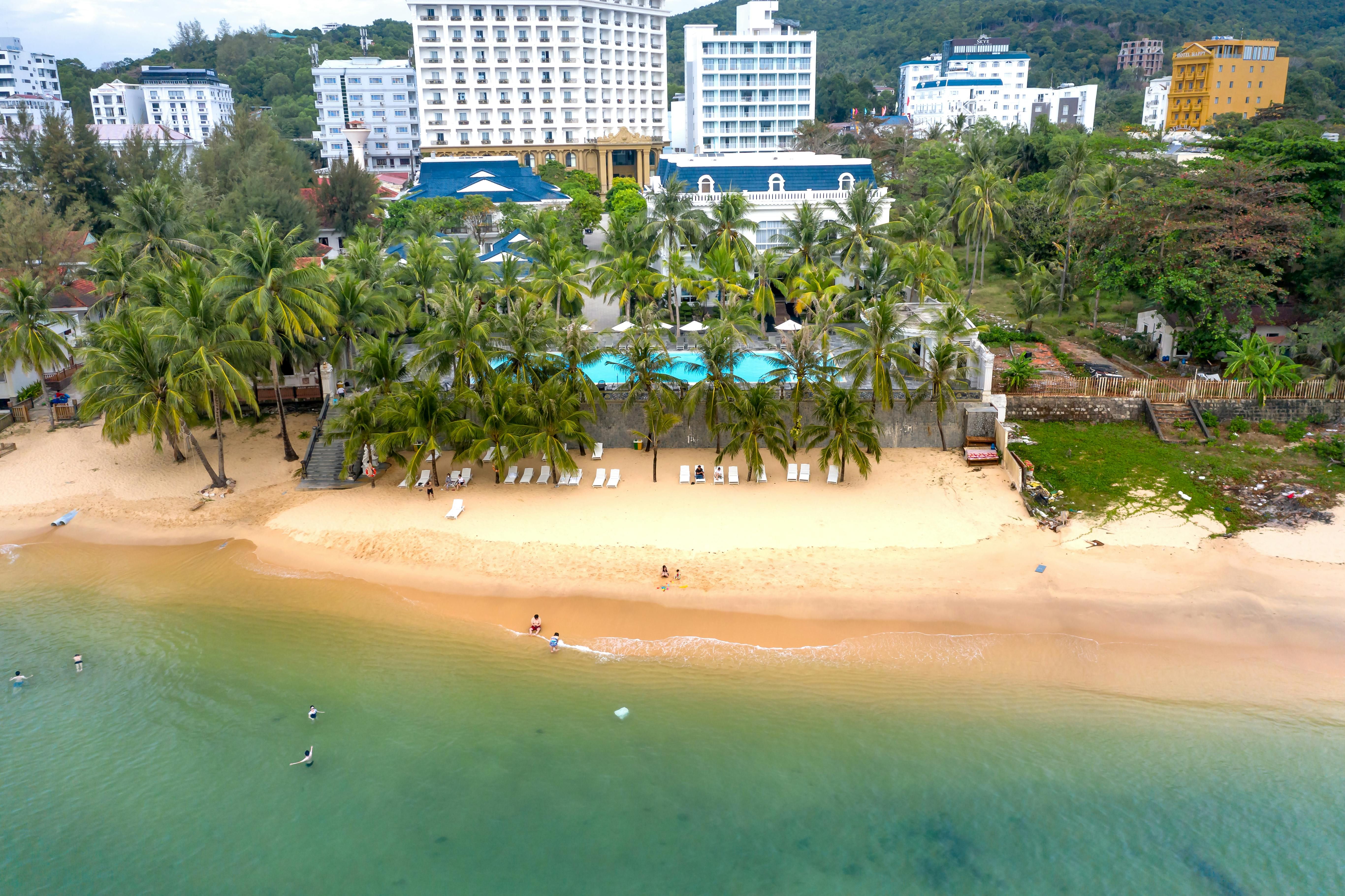 Vietnam — A stunning aerial shot of a tropical beach resort with palm trees and clear ocean waters.