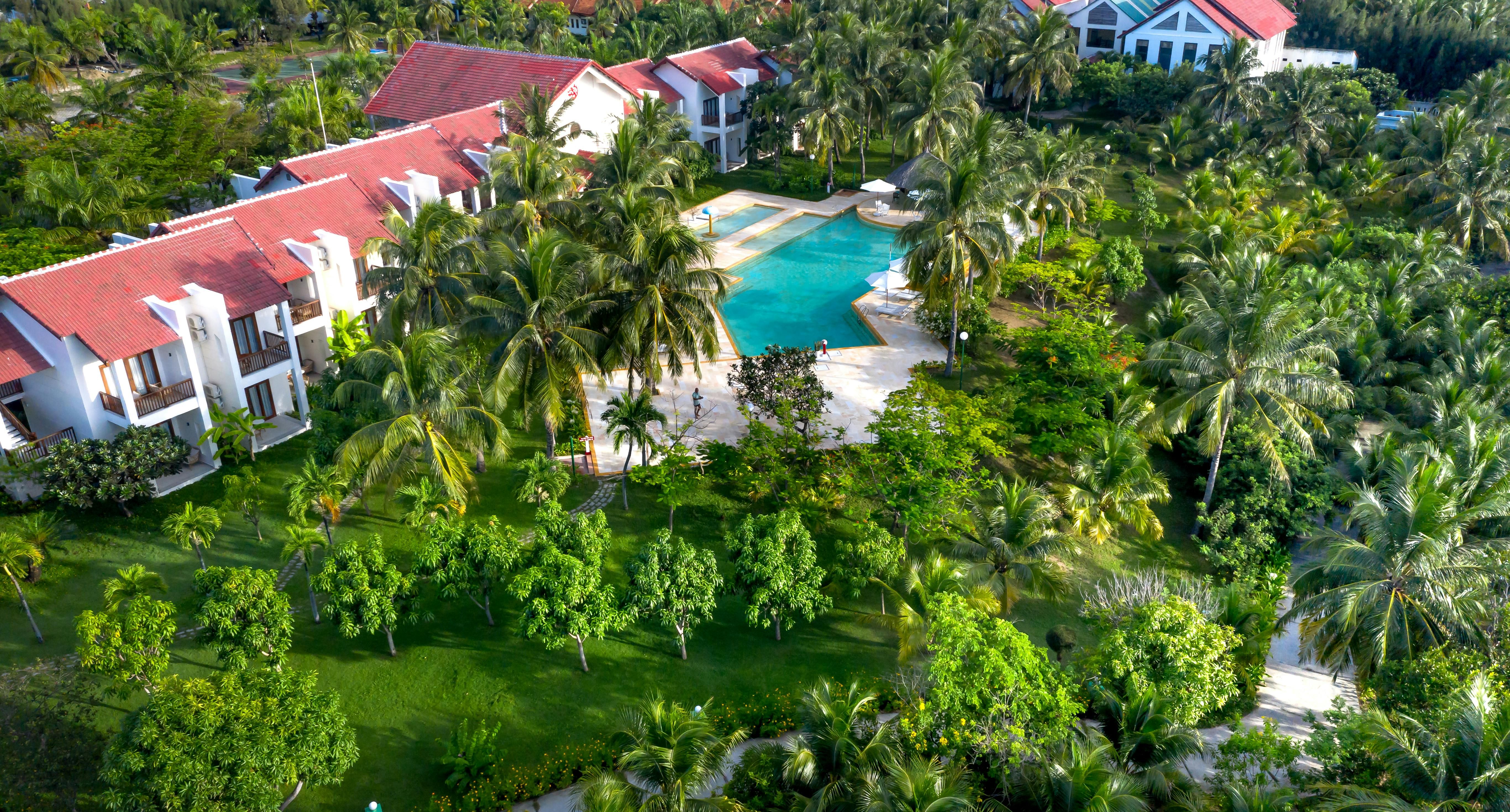 Vietnam — Aerial view of a beautiful tropical resort featuring lush greenery and a sparkling swimming pool.