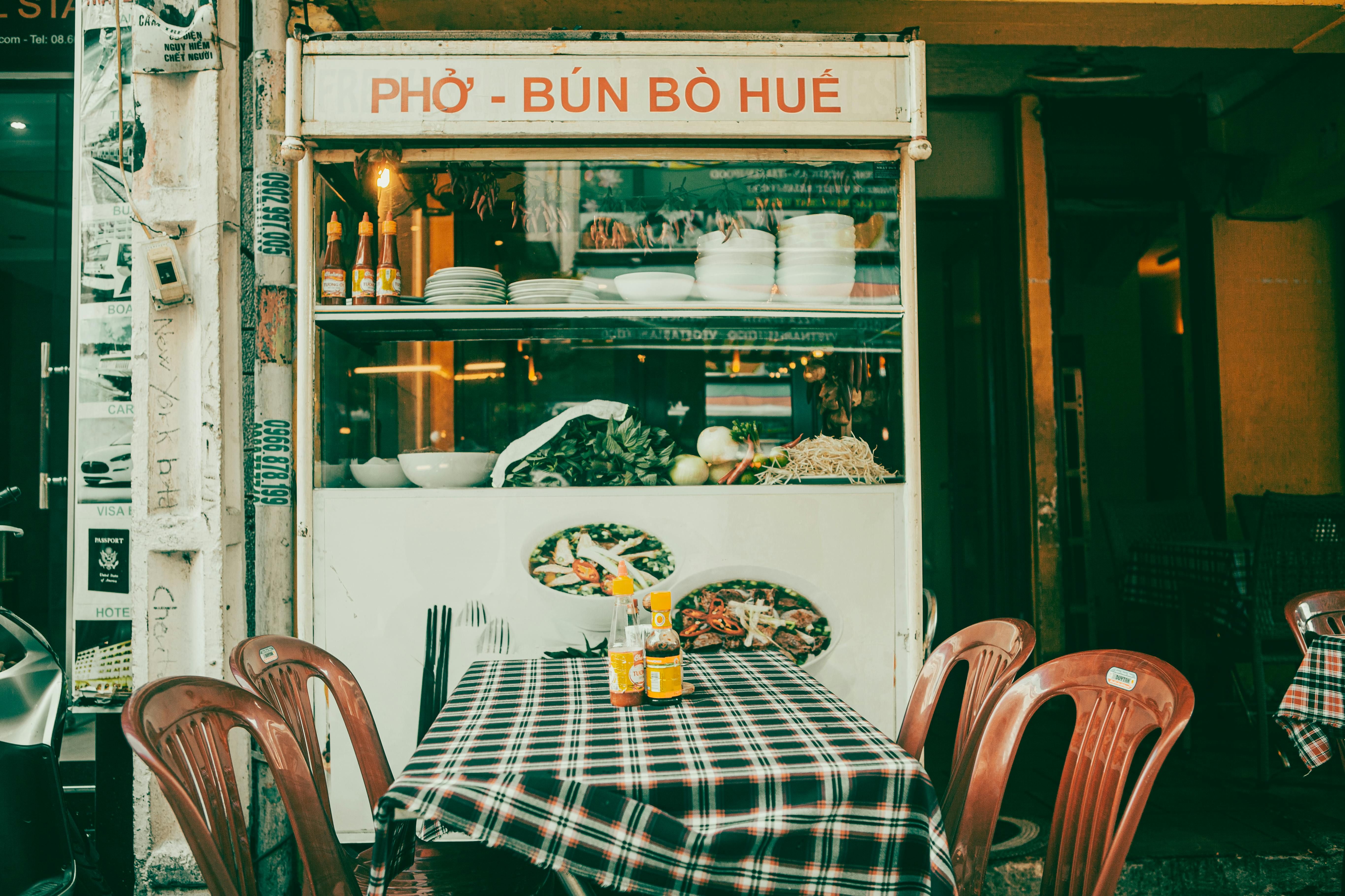 Vietnam — Authentic Vietnamese pho shop in Ca Mau with traditional dishes and inviting outdoor seating.