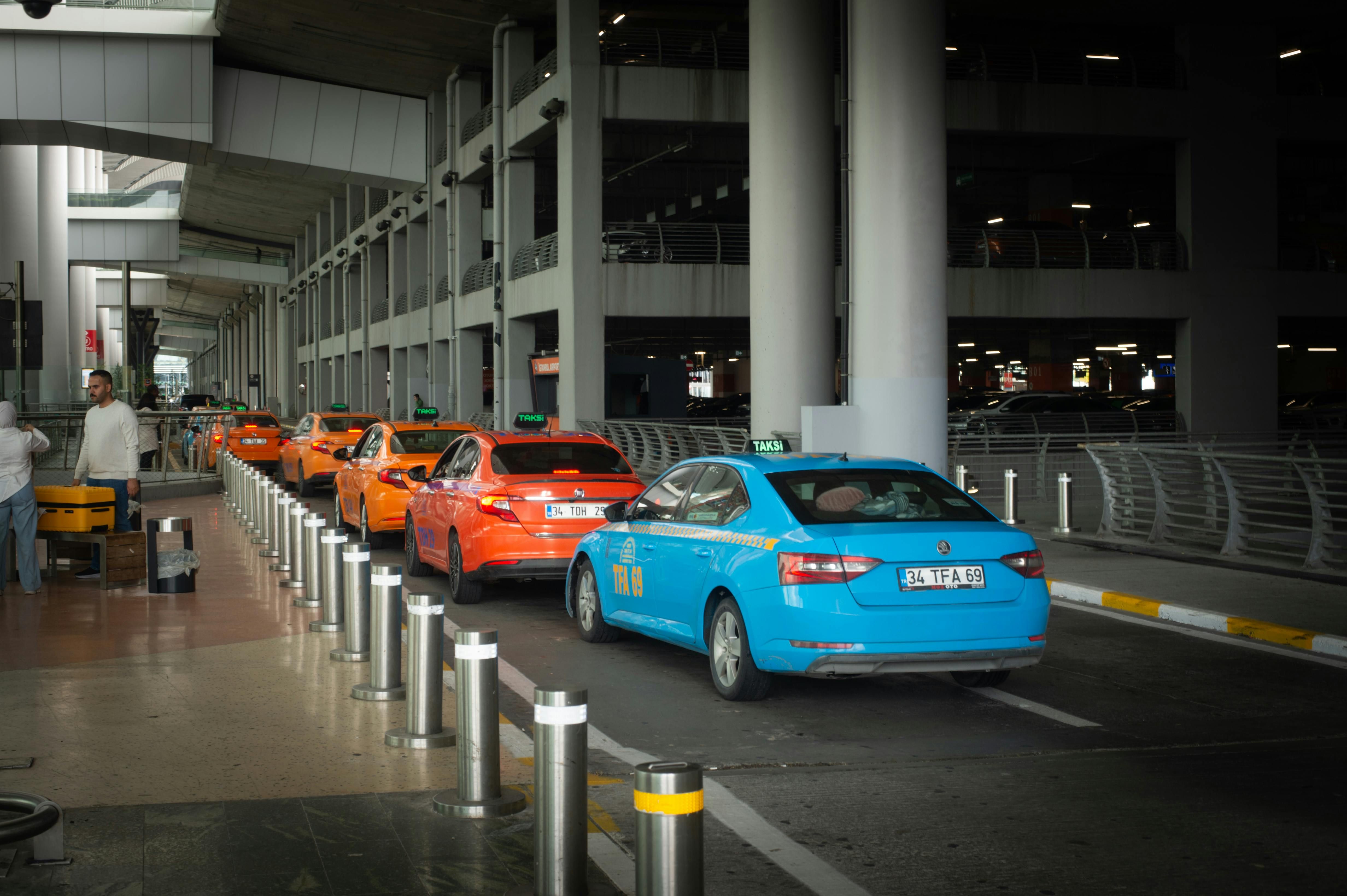 Vietnam — Vibrant taxis lined up at Istanbul Airport arrival terminal with passengers and drivers interacting.