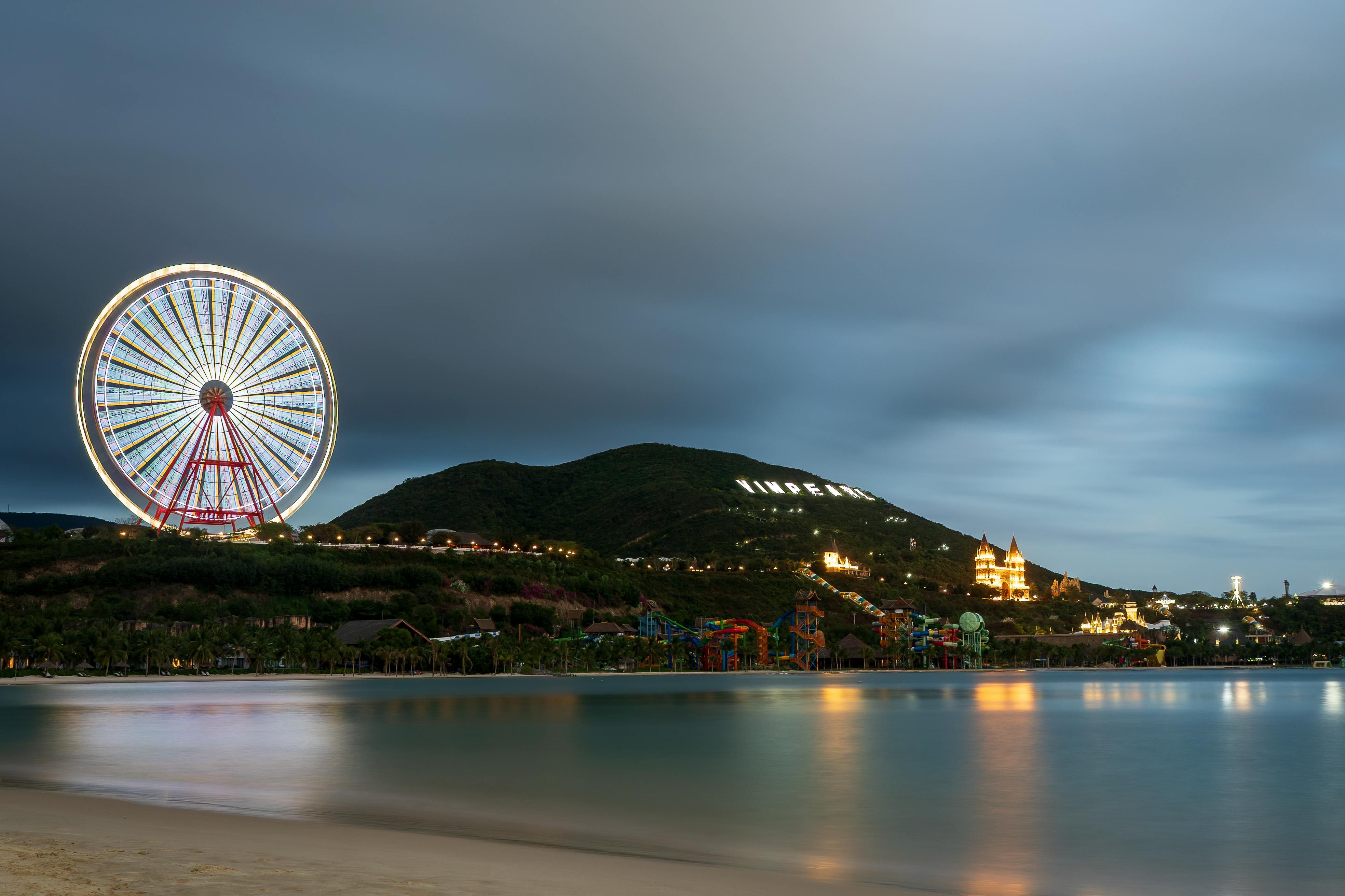 Vietnam — Illuminated Vinpearl ferris wheel and amusement park at night.
